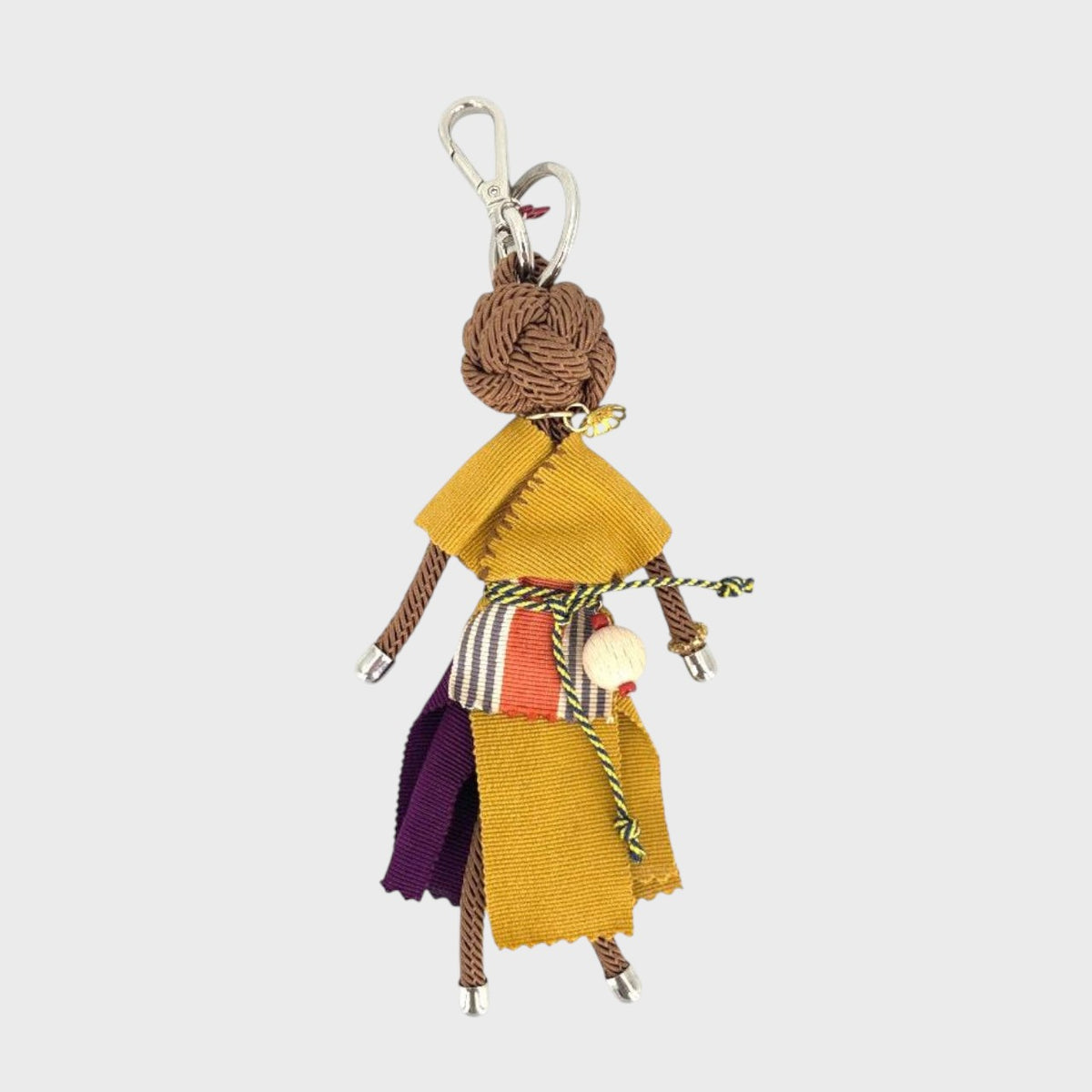 Colorful fabric macramé doll keychain on a white background