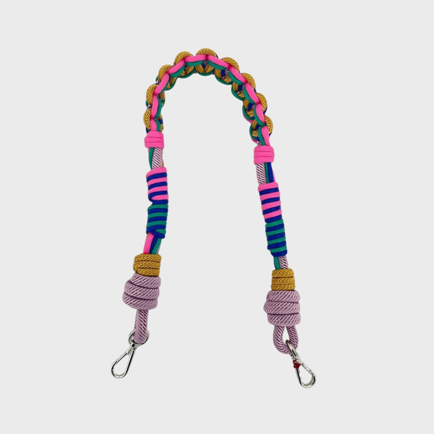 Multicolored braided macramé bag strap in bright pink, blue, and yellow with metal hooks on a light gray background.