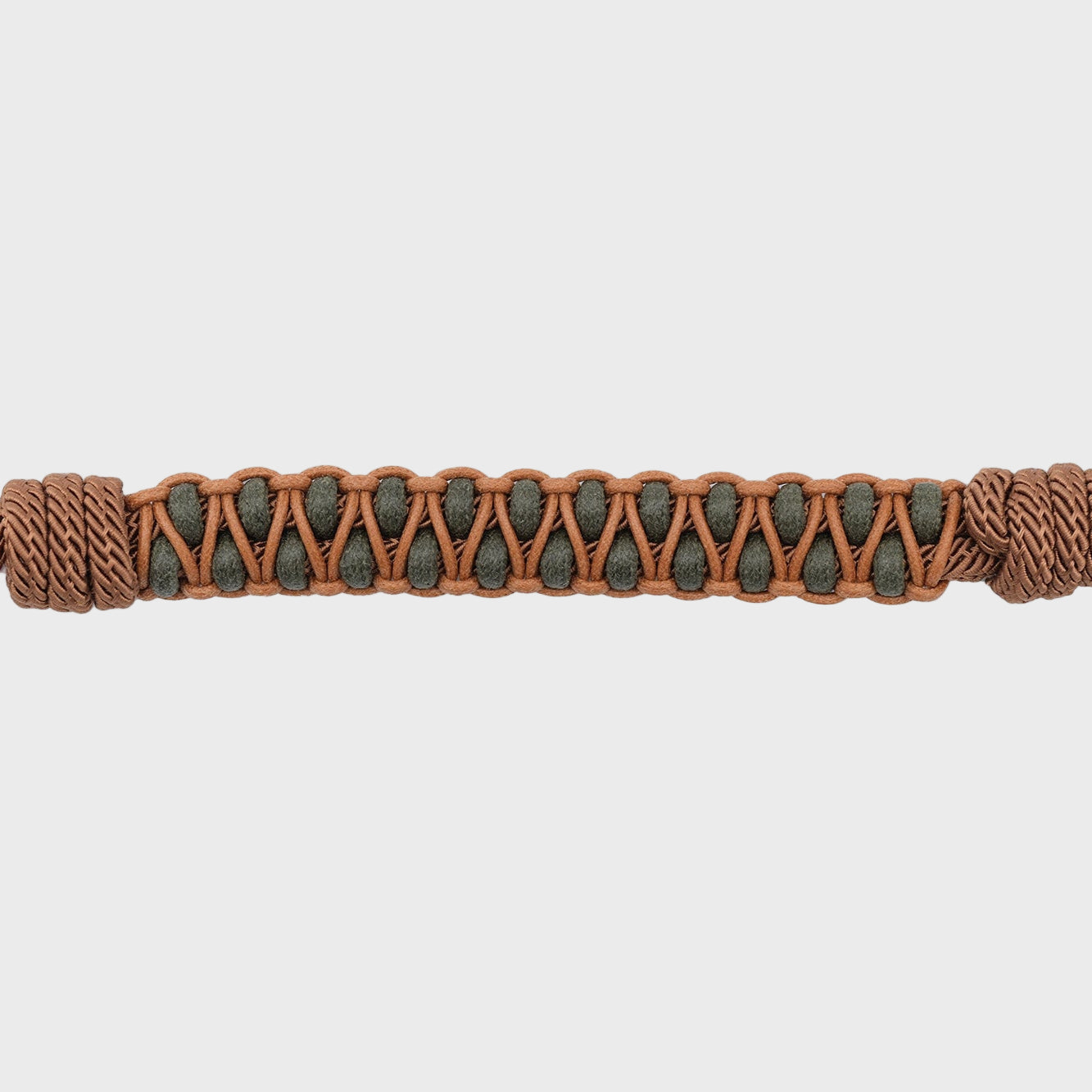 Brown and green braided bracelet on a light gray background