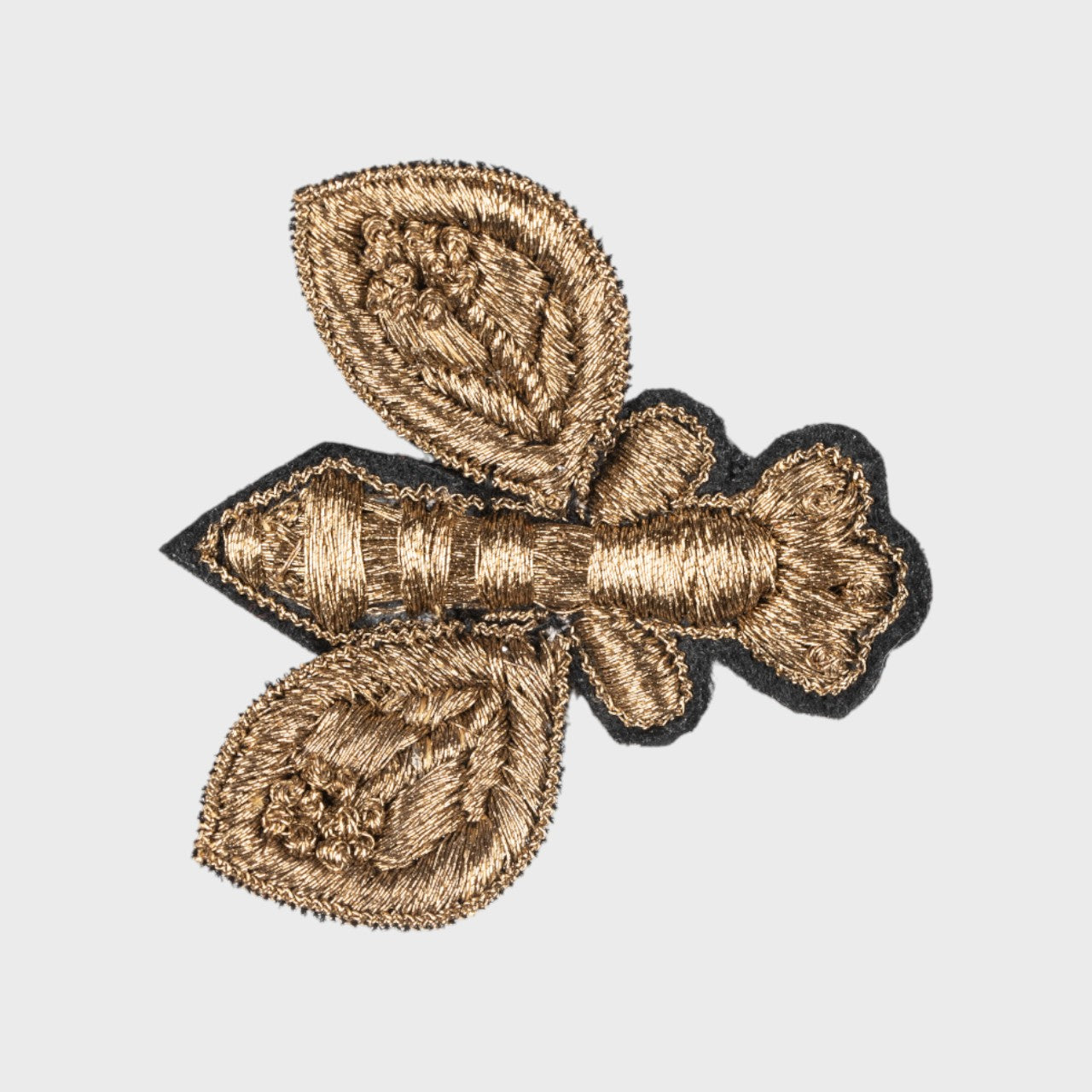 An embroidered brooch representing a golden fly. 