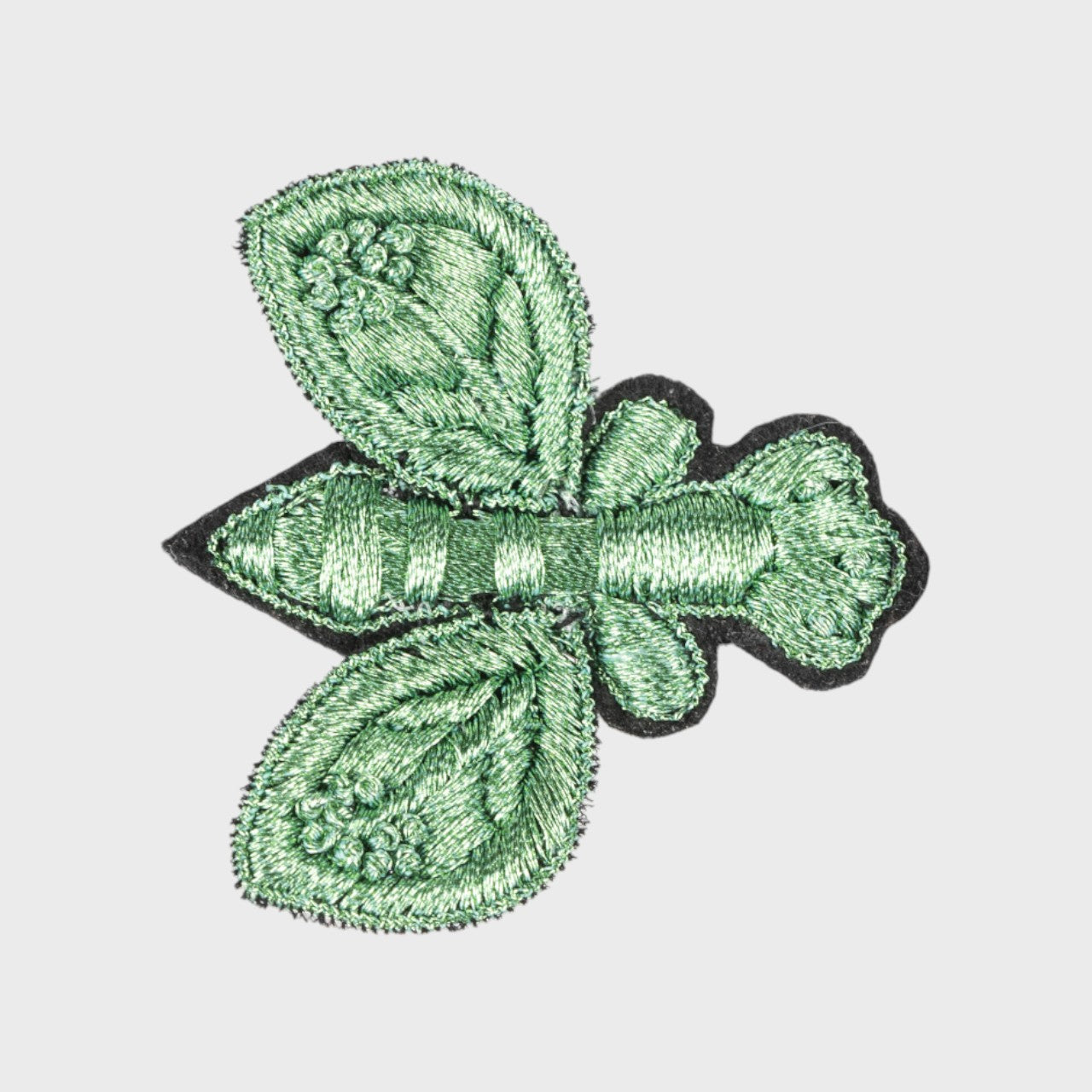 An embroidered brooch representing a green fly. 