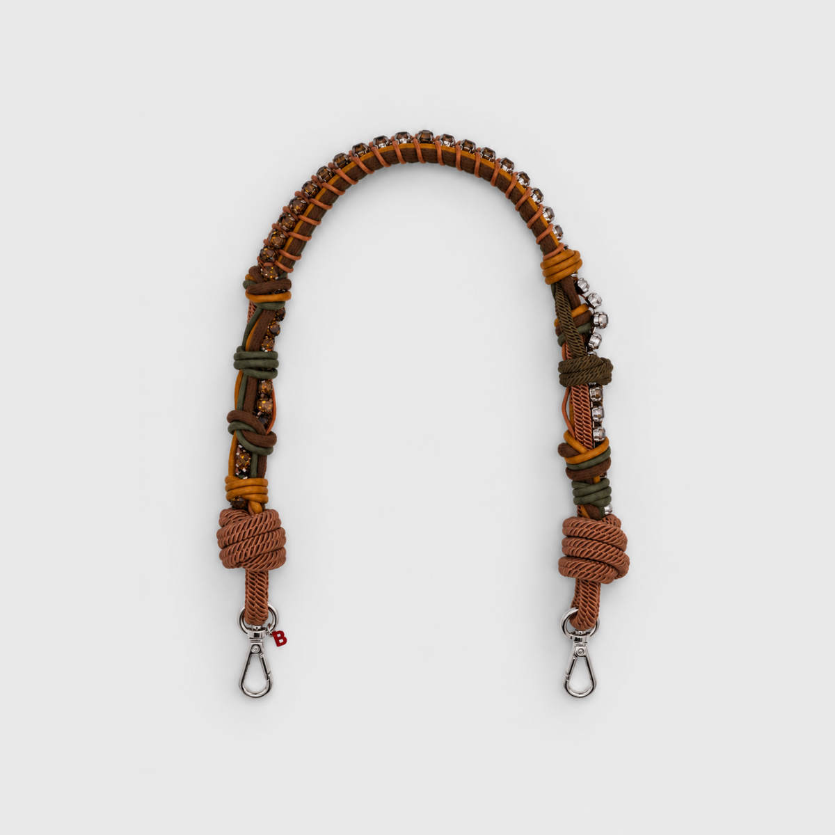 Multicolored braided macramé bag strap in dark green and brown, featuring some green colored beads and shown on a light grey background.