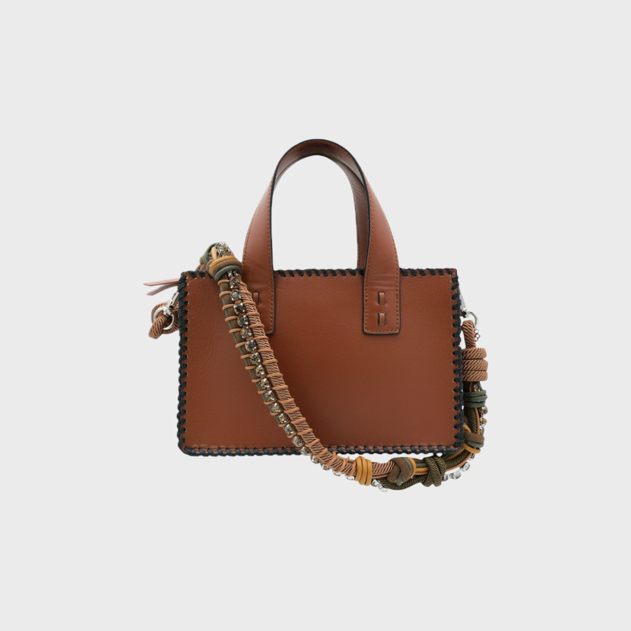 Multicolored braided macramé bag strap in dark green and brown, featuring some green colored beads and shown on a brown leather Maori handbag.