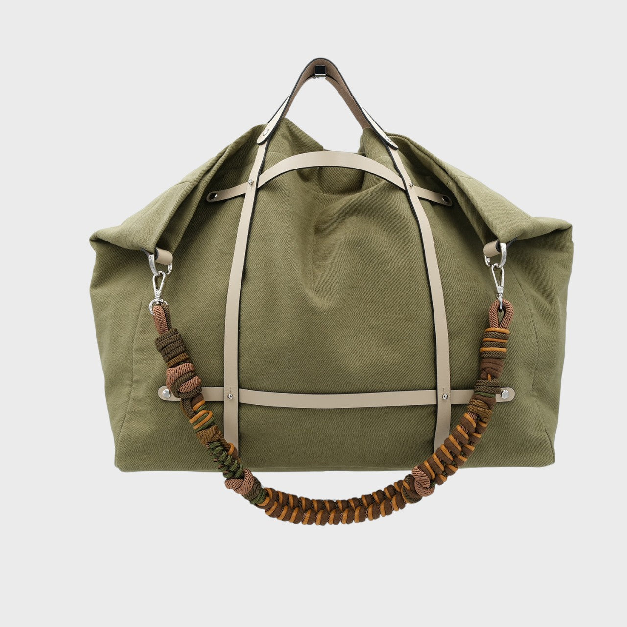 Multicolored braided macramé bag strap in  dark green and brown, shown on a green cotton Candide Weekender bag.