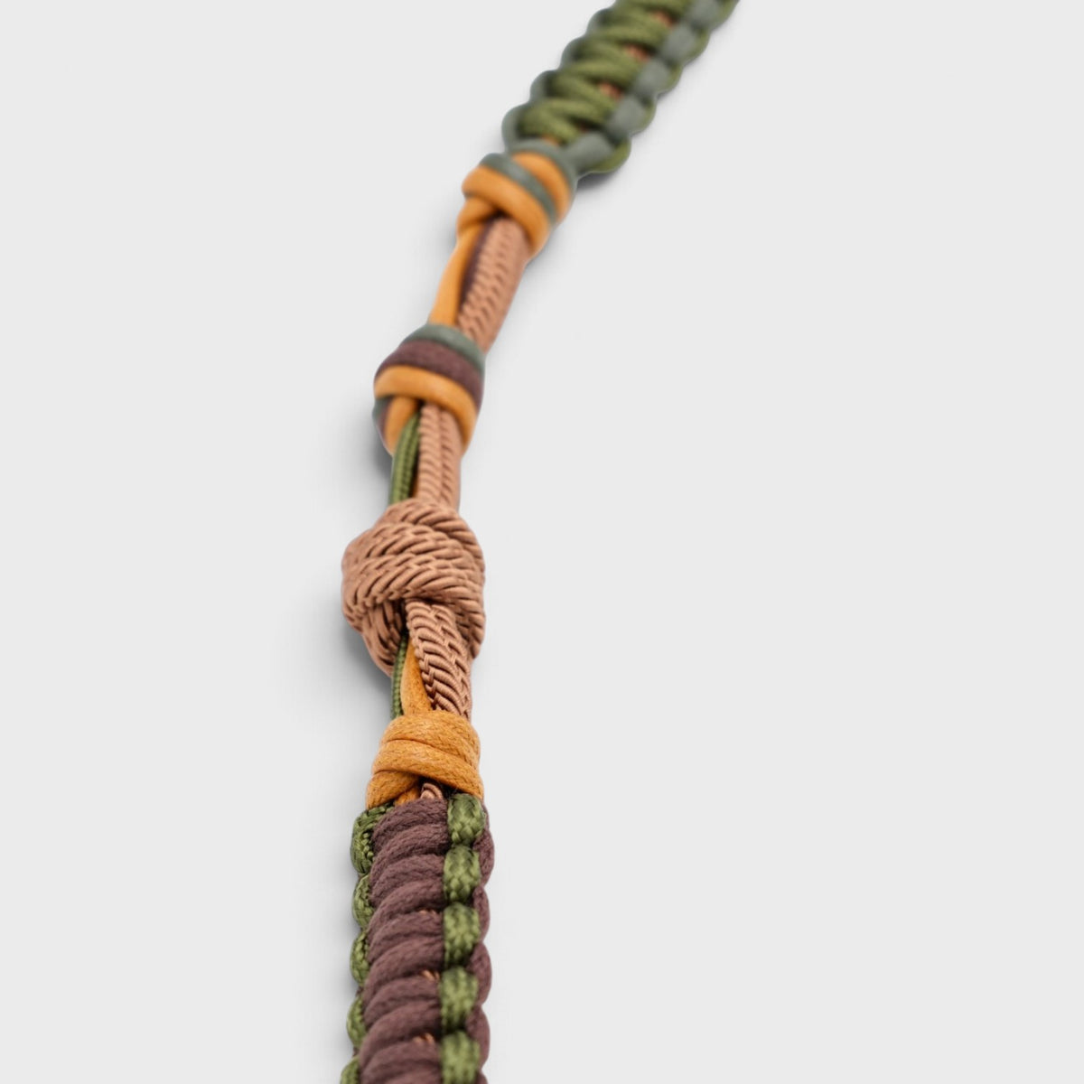 A macramé brown and green bag strap. 