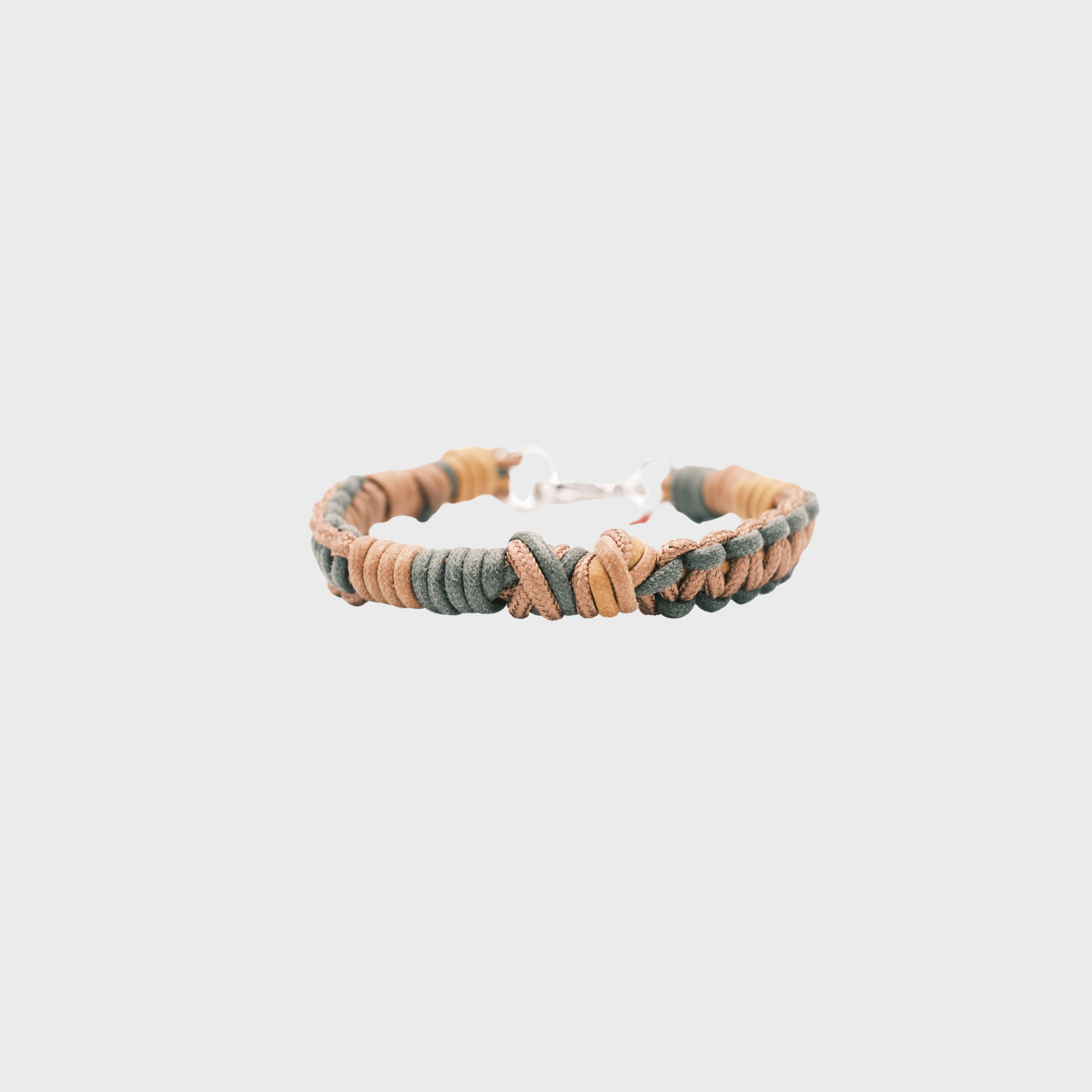 A braided macramé cord collar in shades of dark green and brown with a silver clasp, centered on a light gray background.