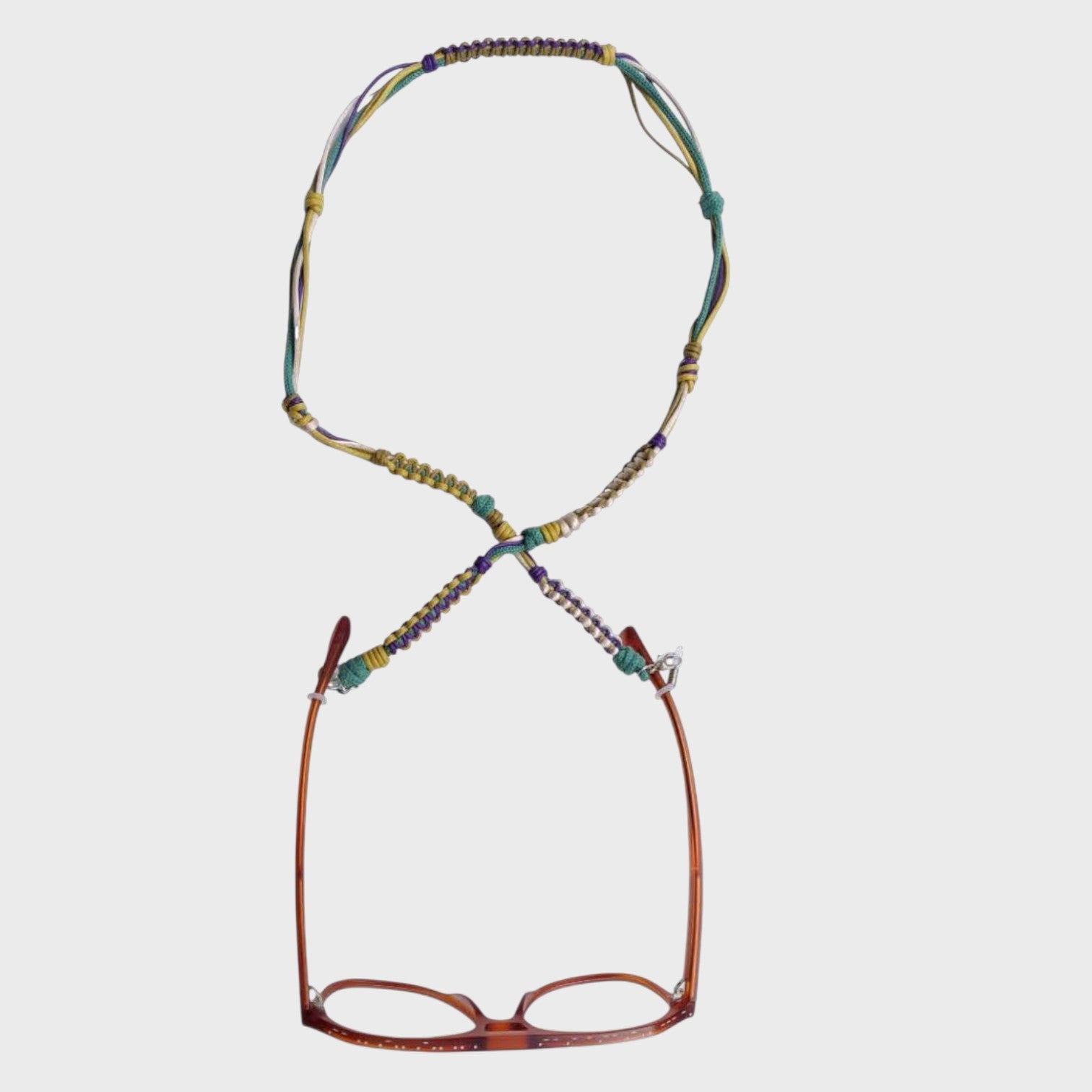 Woven eyeglass holder with yellow, green, beige and purple details on a white background