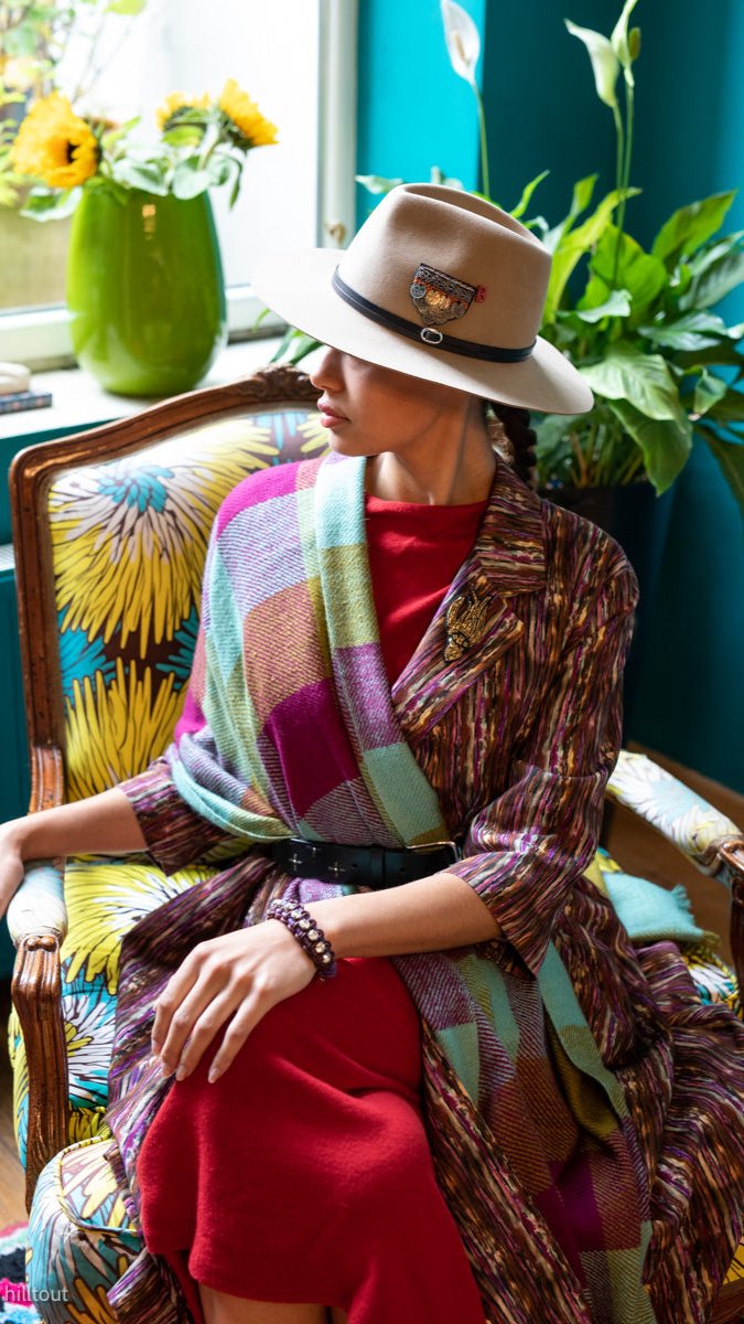 A woman wearing the green purple and brown plaidy shawl