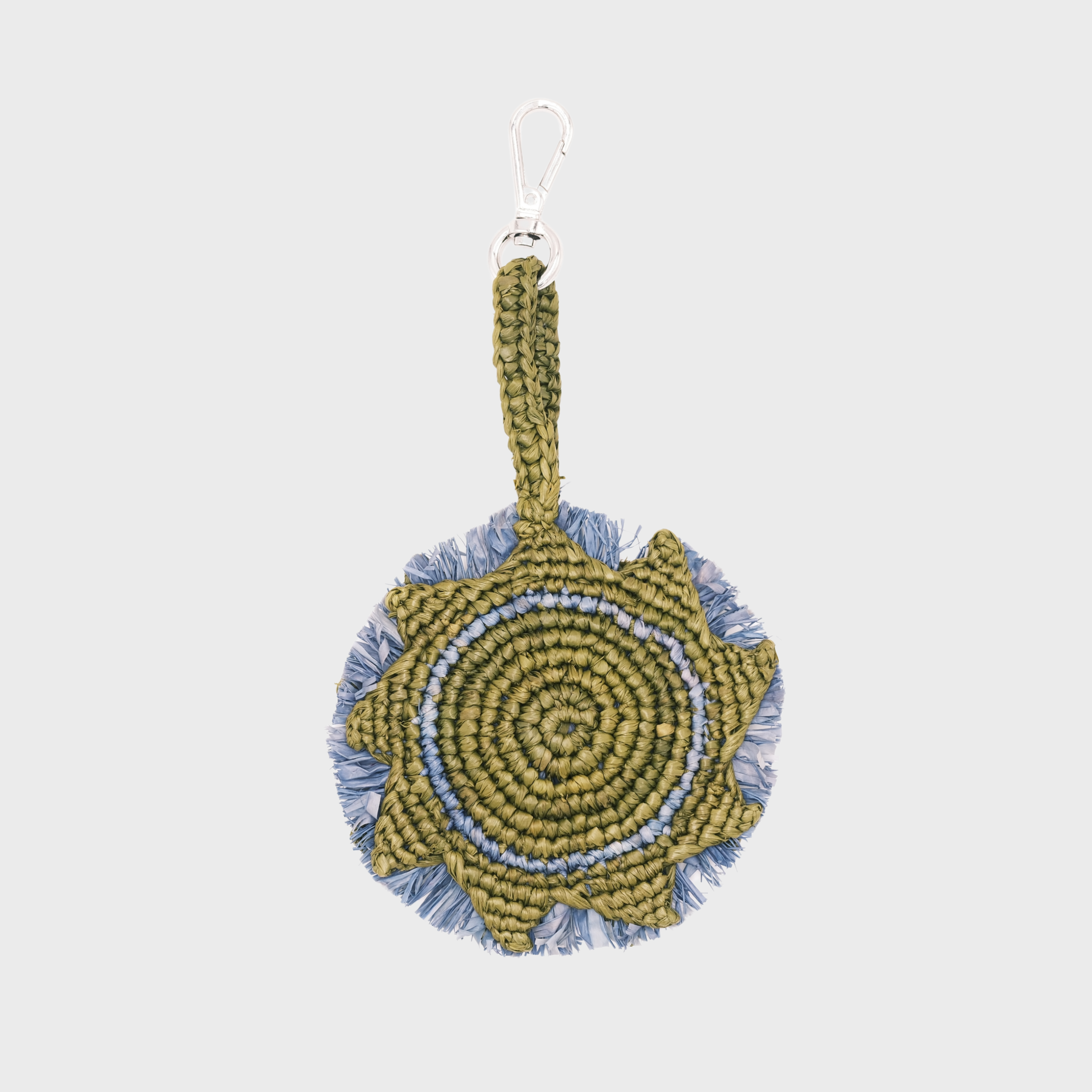 A handmade circular raffia keychain  in olive green and light blue, representing the sun with a silver metal lobster clasp.