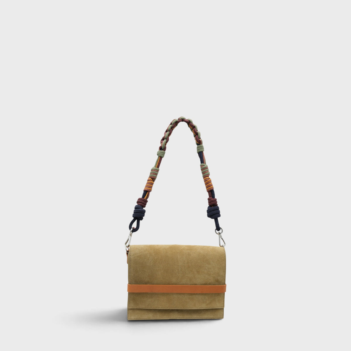 A small rectangular flap bag in green suede with a horizontal orange-brown leather band across the middle and a long braided shoulder strap in mixed earthy colors, shown on a light gray background.