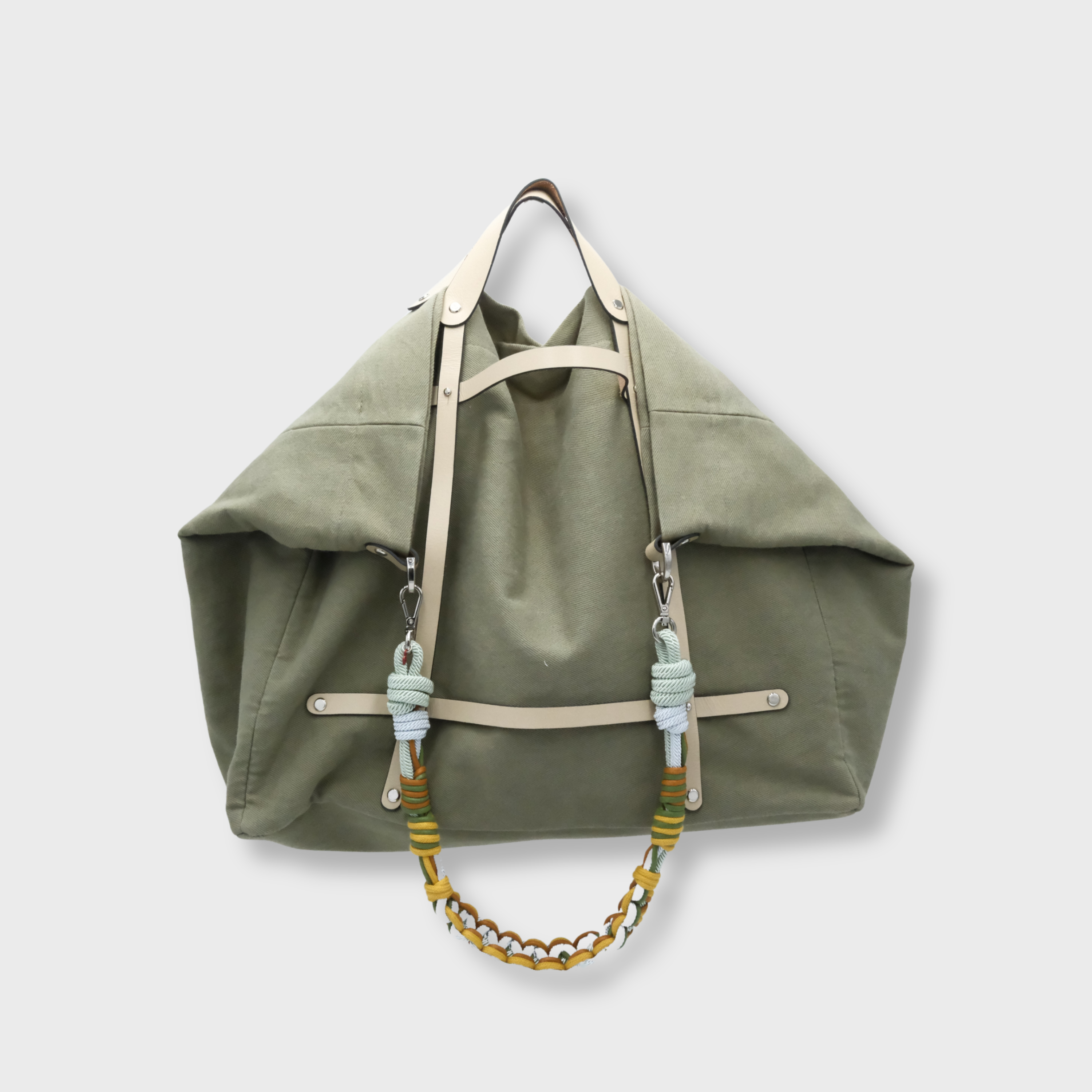Green canva weekend or duffle bag with a white leather harness, paired with a colourful shoulder strap in blue, green, yellow and brown strap. 