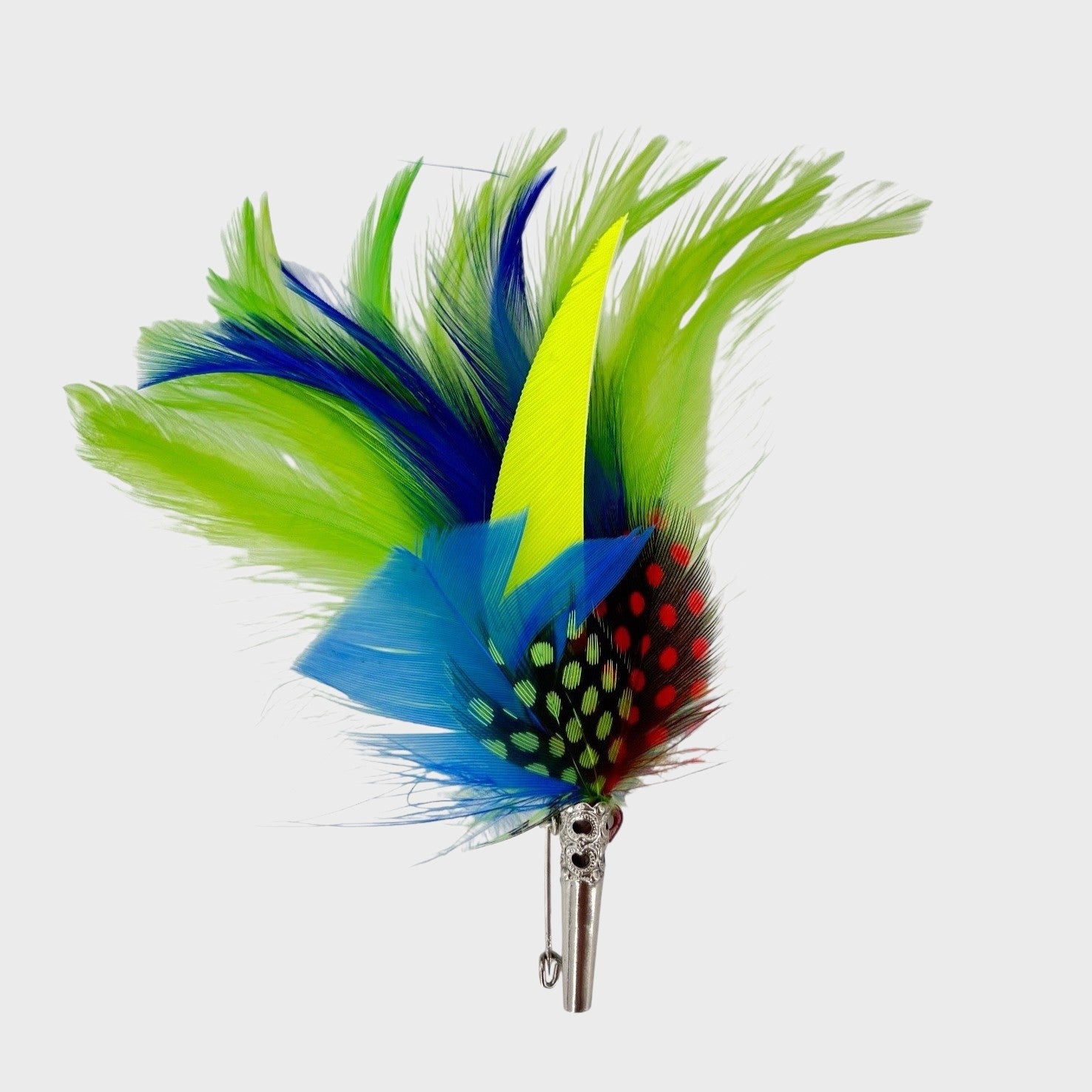 Green, blue and yellow feathered brooch on a light gray background