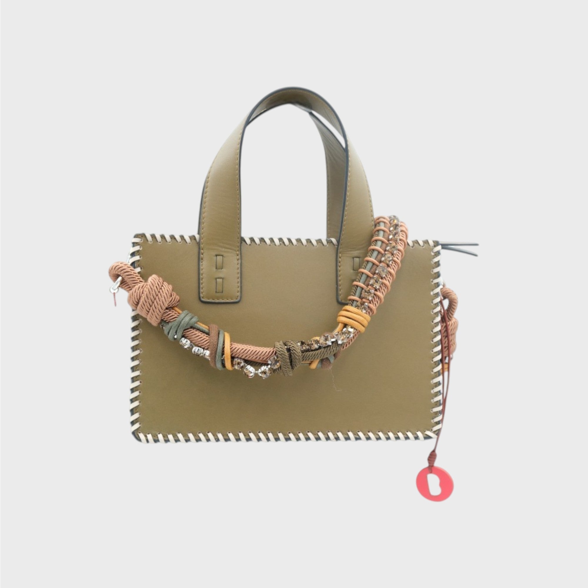 A green leather handbag with white details on the side and brown and green strap. 