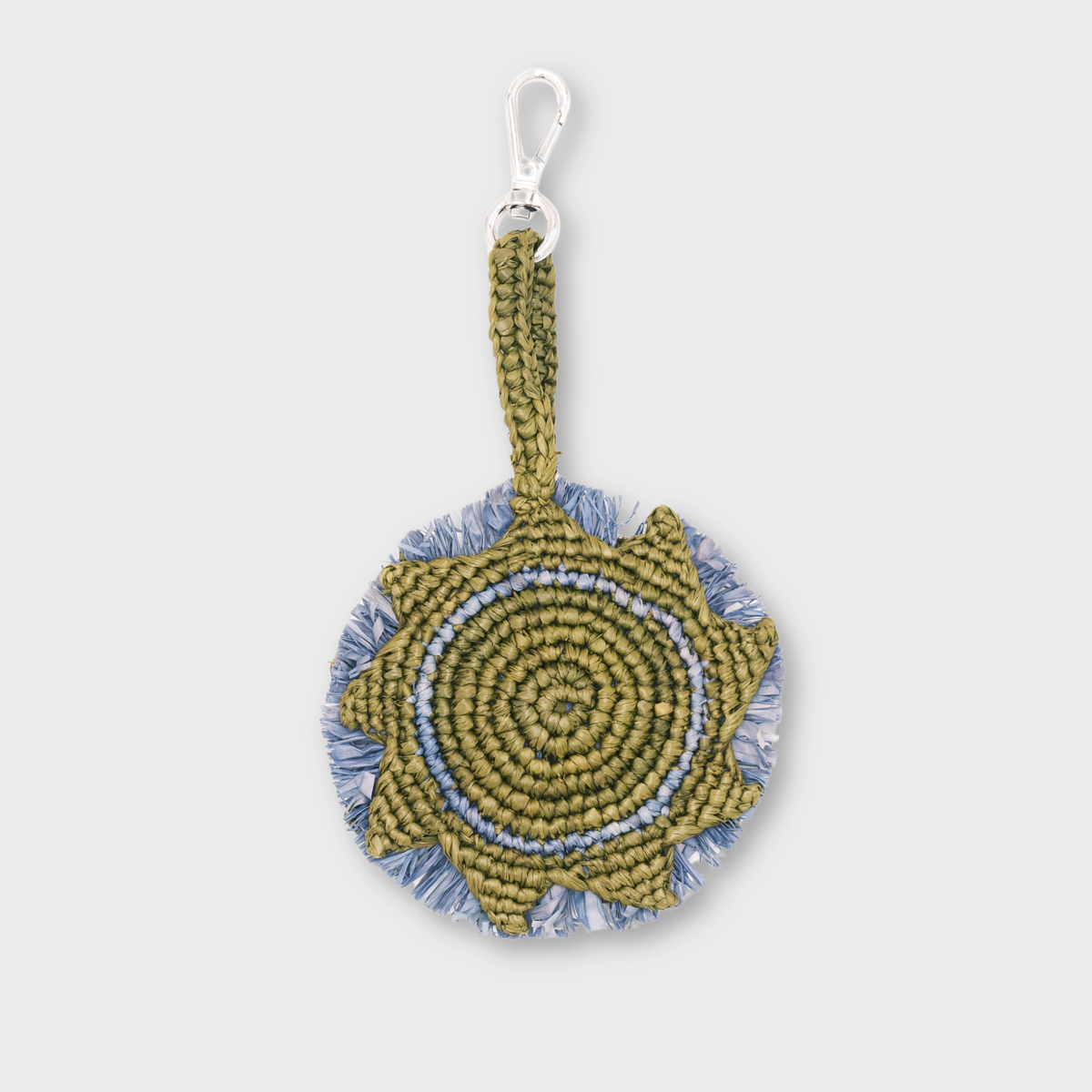 A handmade circular raffia keychain  in olive green and light blue, representing the sun with a silver metal lobster clasp.
