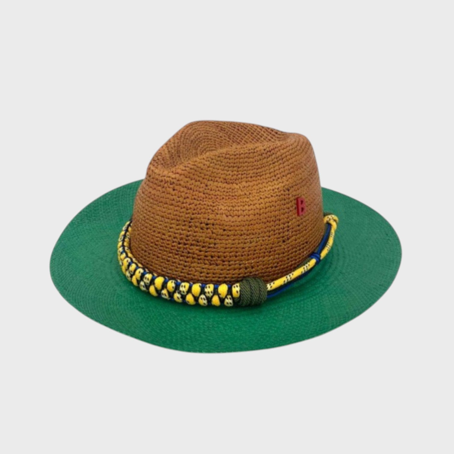 A brown and green raffia hat with a yellow macramé woven band around it. 