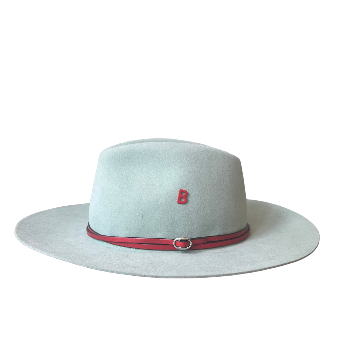 Light green fedora hat with a red band and letter 'B' pinned on it on a white background