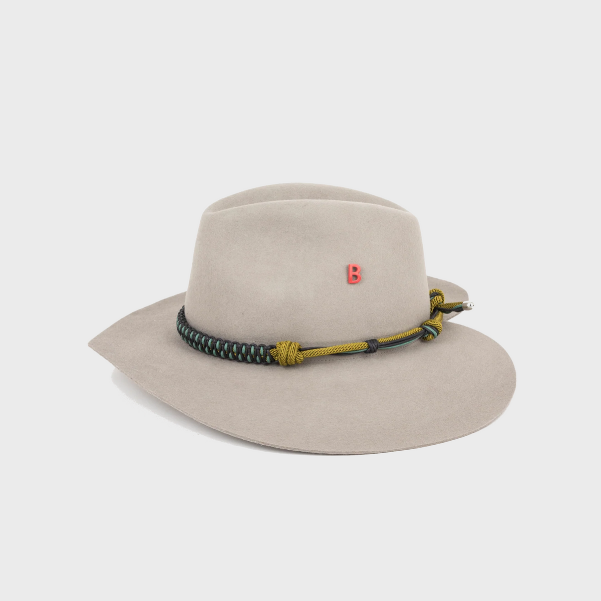 Beige wool hat shaped as a heart with a braided band on a light gray background