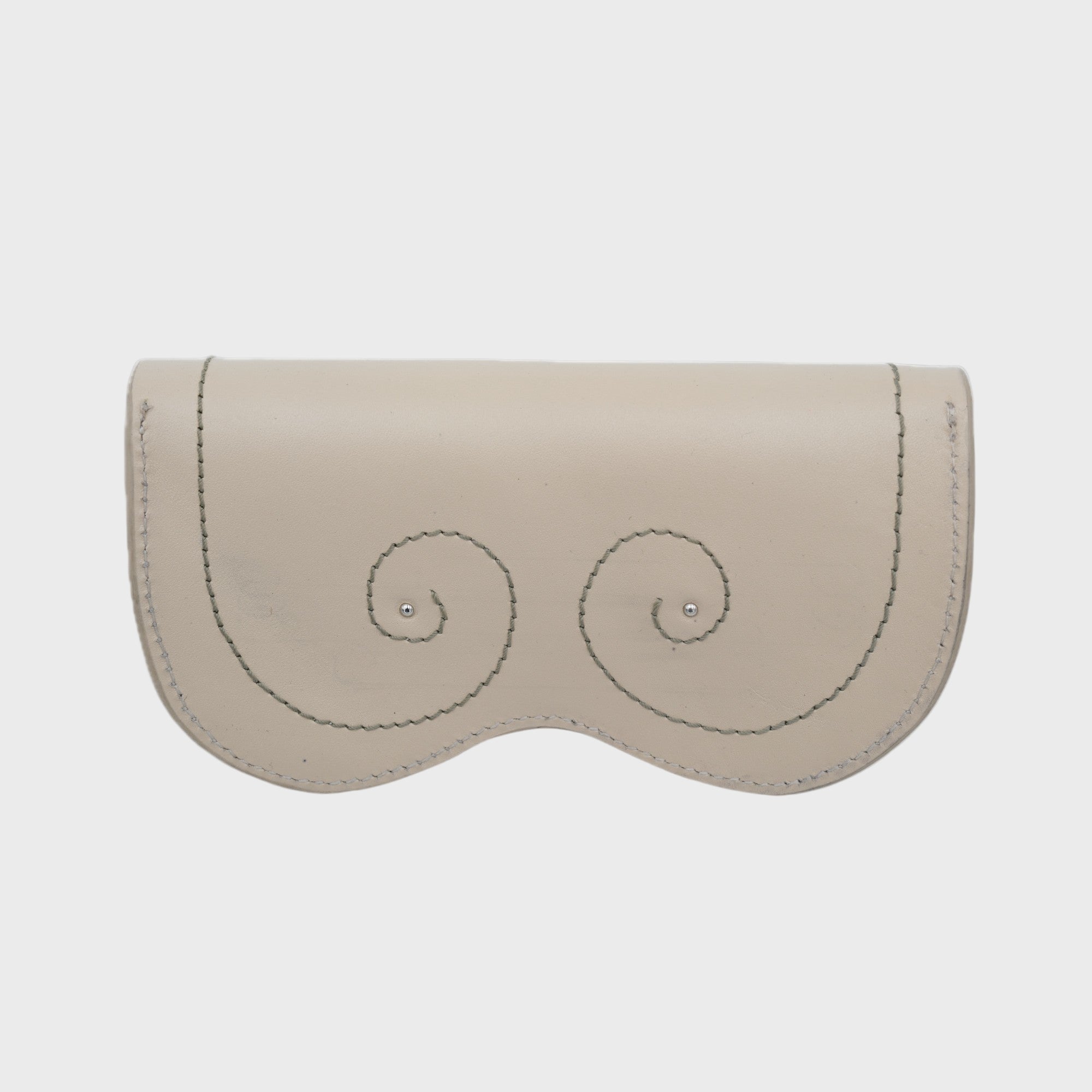 A white glasses case with small embroidered symbols on it. 