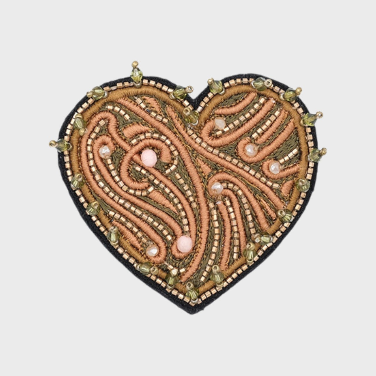 An embroidered brooch representing a heart with green and beige details. 