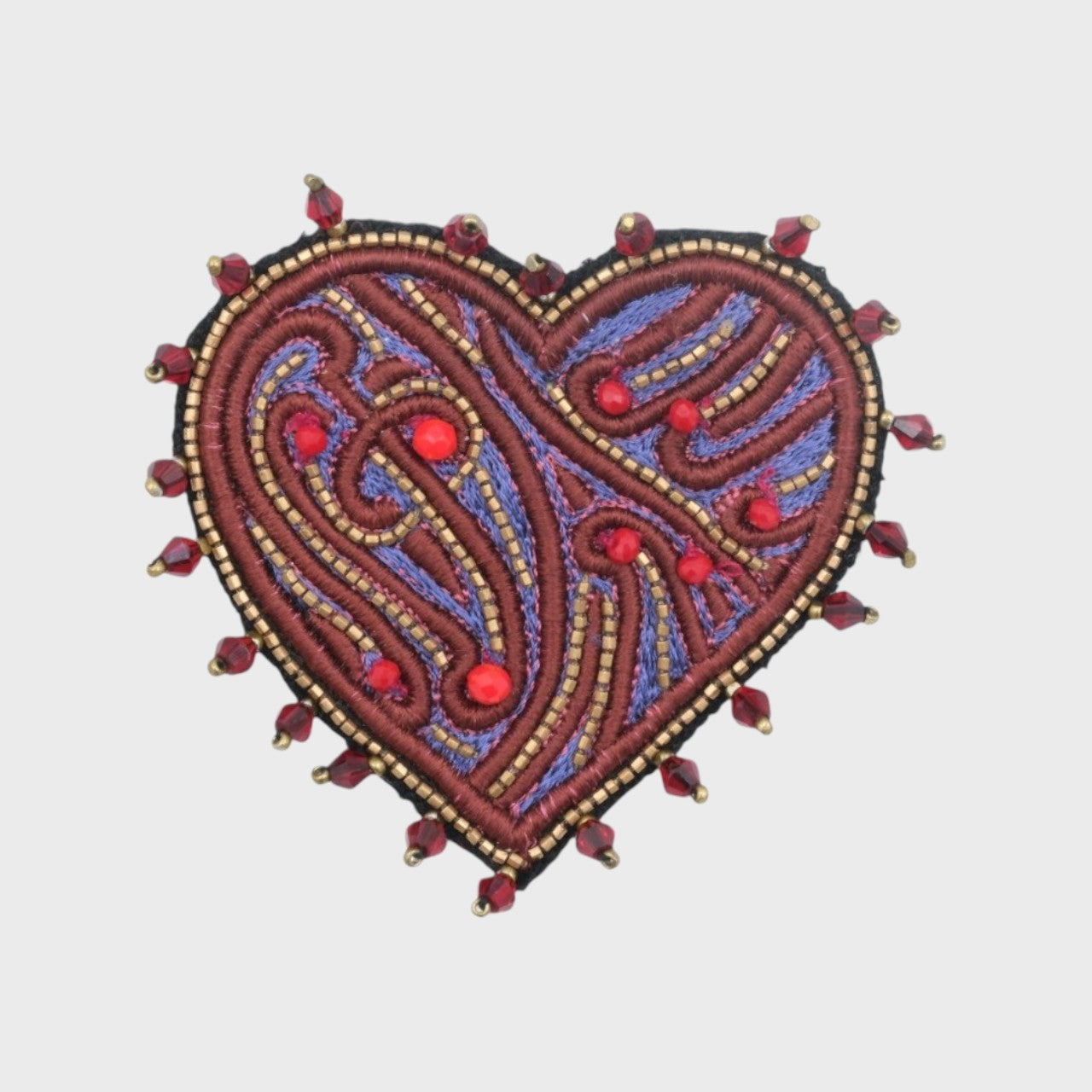 An embroidered brooch representing a heart with purple and violet details. 