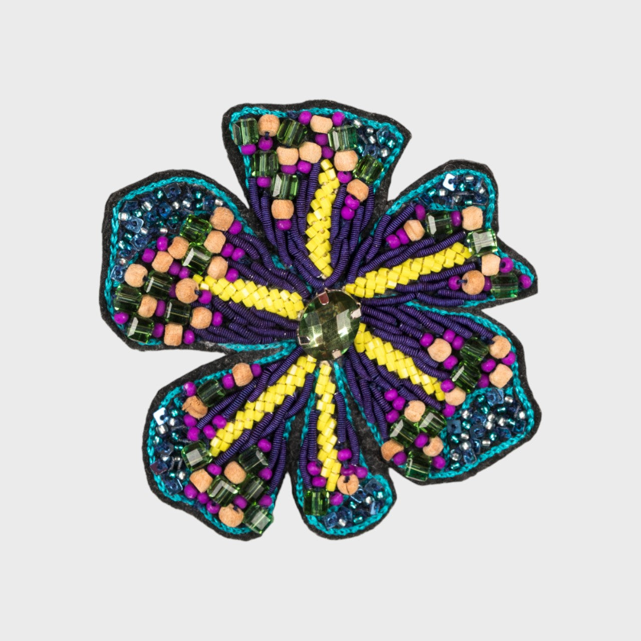 An emlbroidered brooch representing a flower with blue, purple and yellow details. 