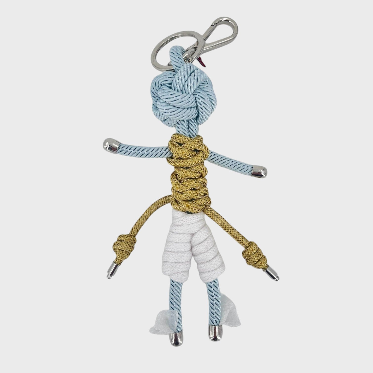 Handmade blue macramé bag charm featuring a character meant to represent Hermes wearing a golden top, white capris and wings at his feet. He is attached to a silver clasp.