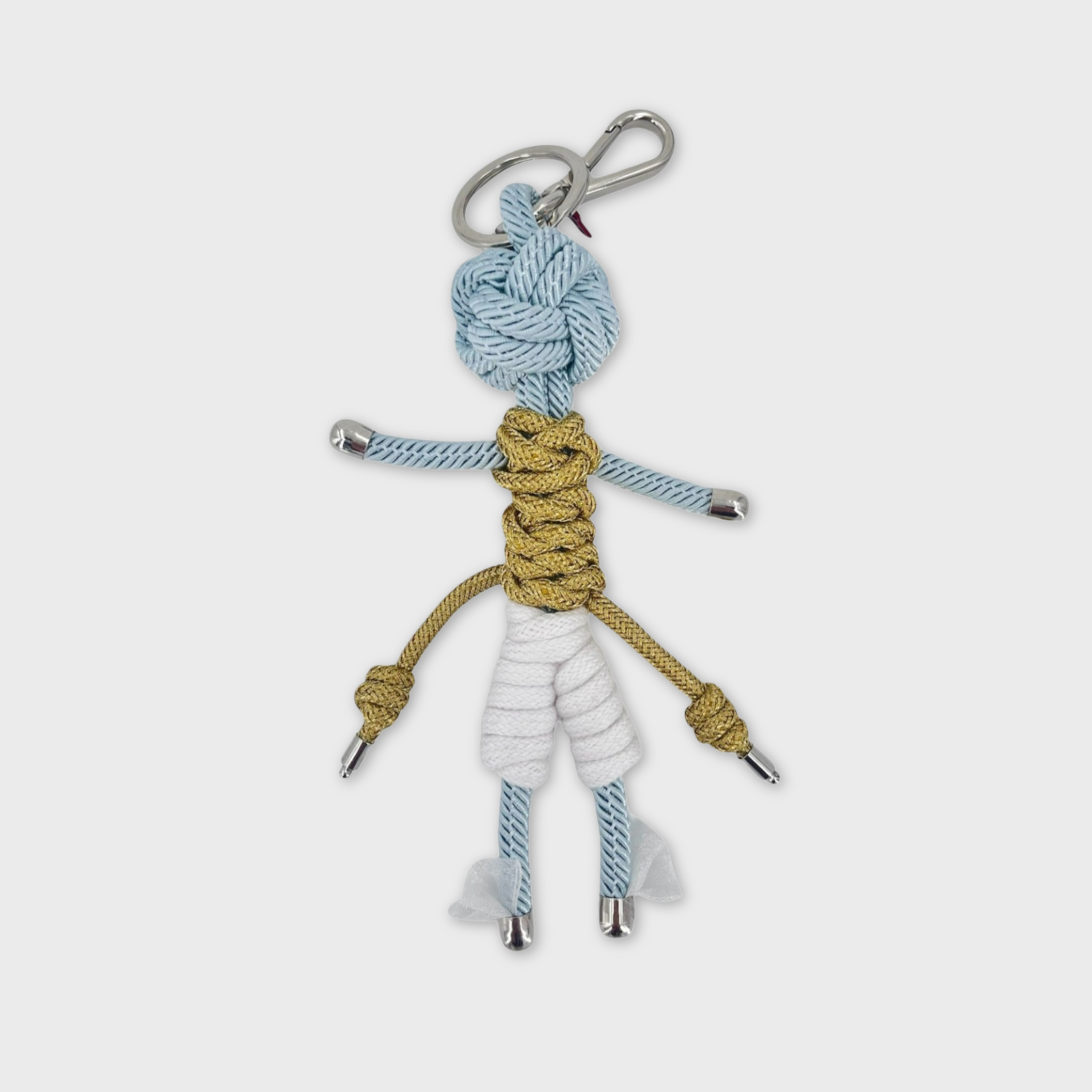 Handmade blue macramé bag charm featuring a character meant to represent Hermes wearing a golden top, white capris and wings at his feet. He is attached to a silver clasp.
