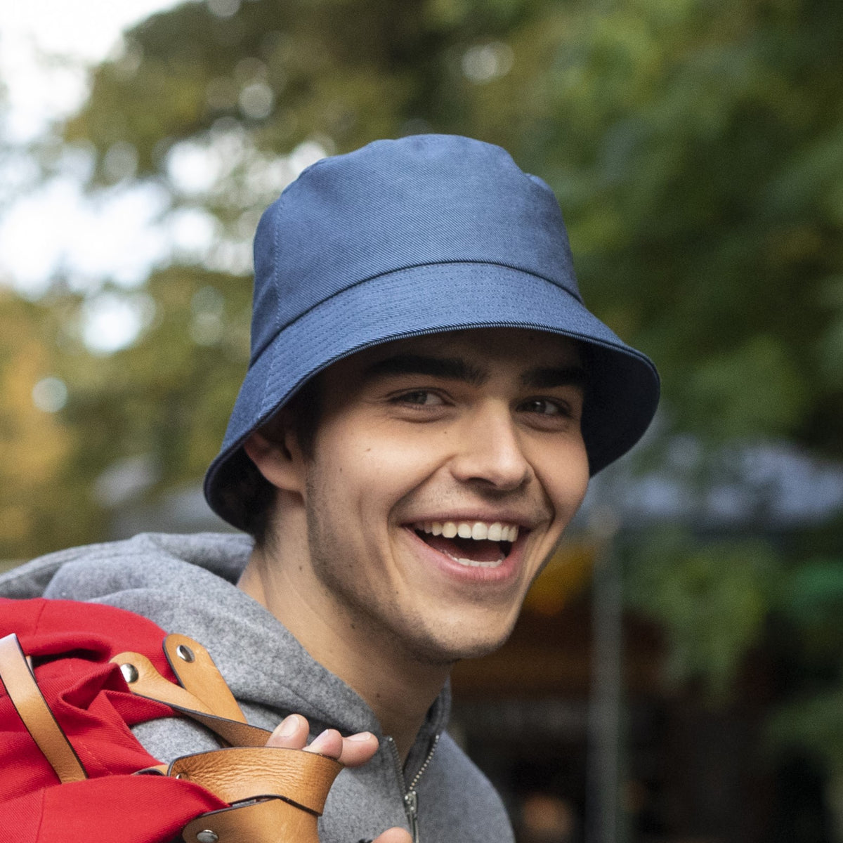 A man wearing a blue jean cotton bucket hat. 