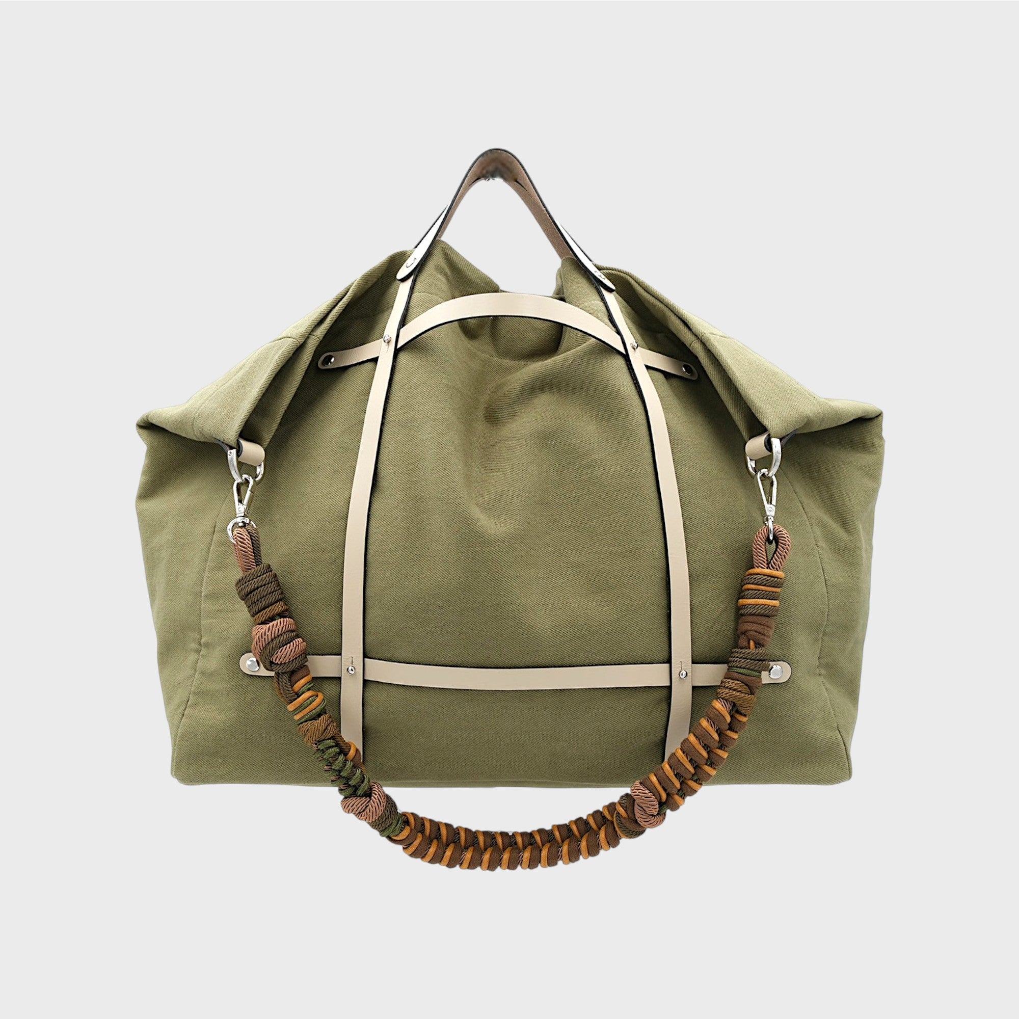 Kaki green candide weekender bag  made out of canvas cotton assembled with a white leather harness and a coloured macramé shoulder strap in green, brown and yellow.