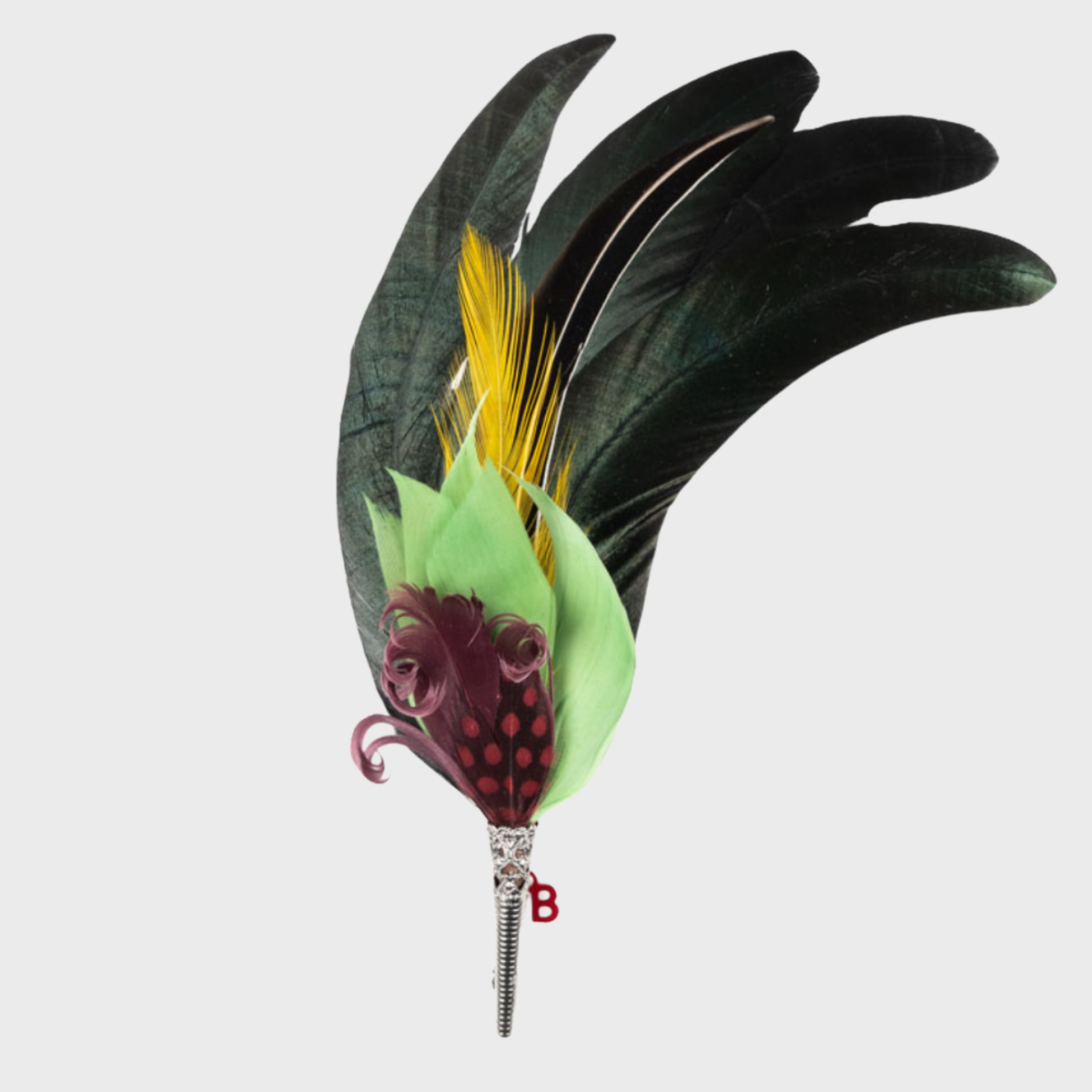 A feather brooch with green, purple, yellow and black feathers. 