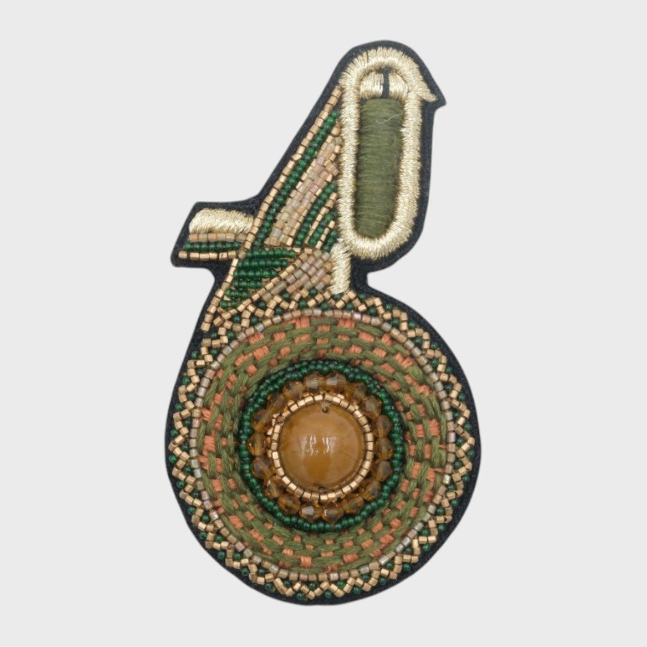An embroidered brooch representing a green kiwi bird with beige details. 
