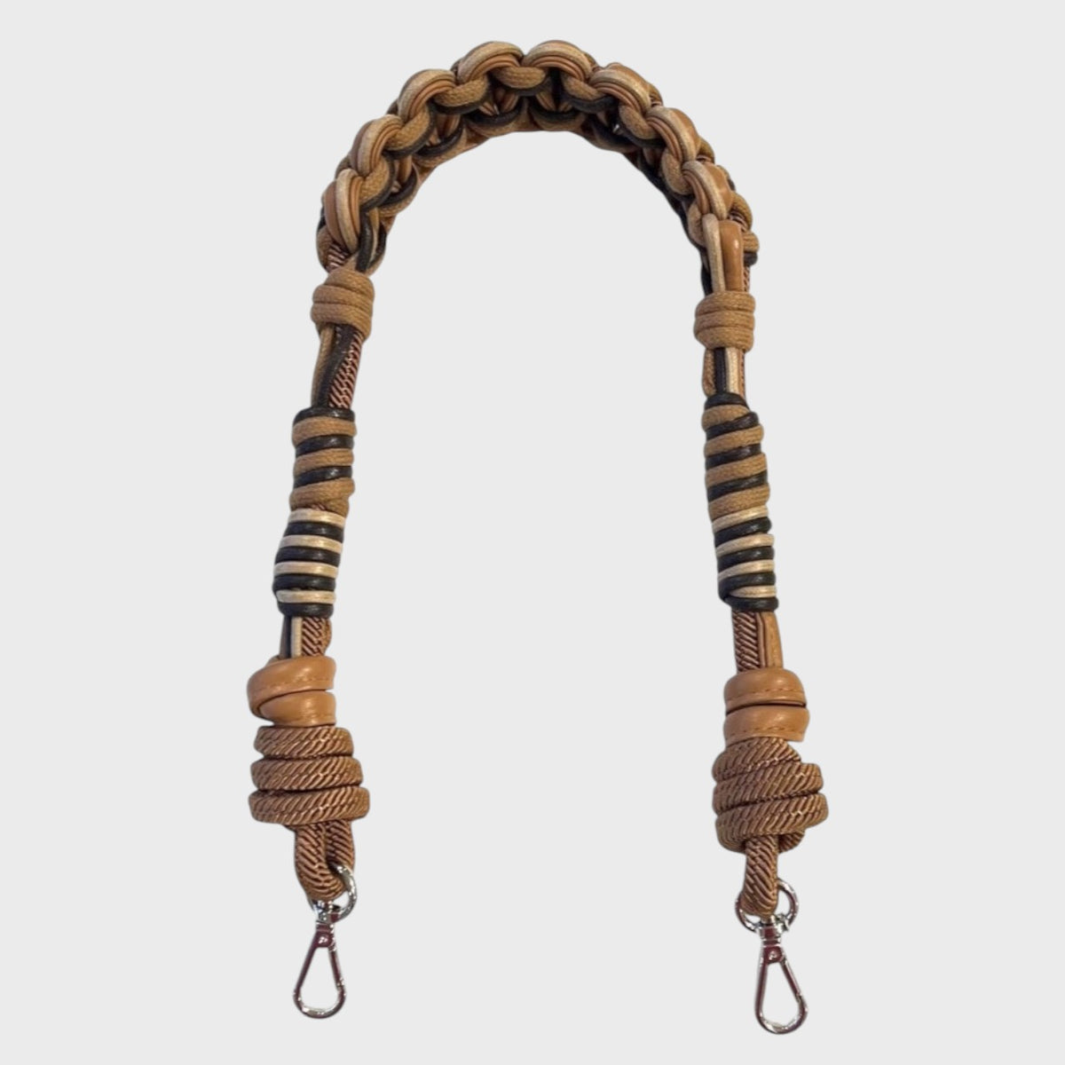 A brown braided bag strap with leather and macramé. 