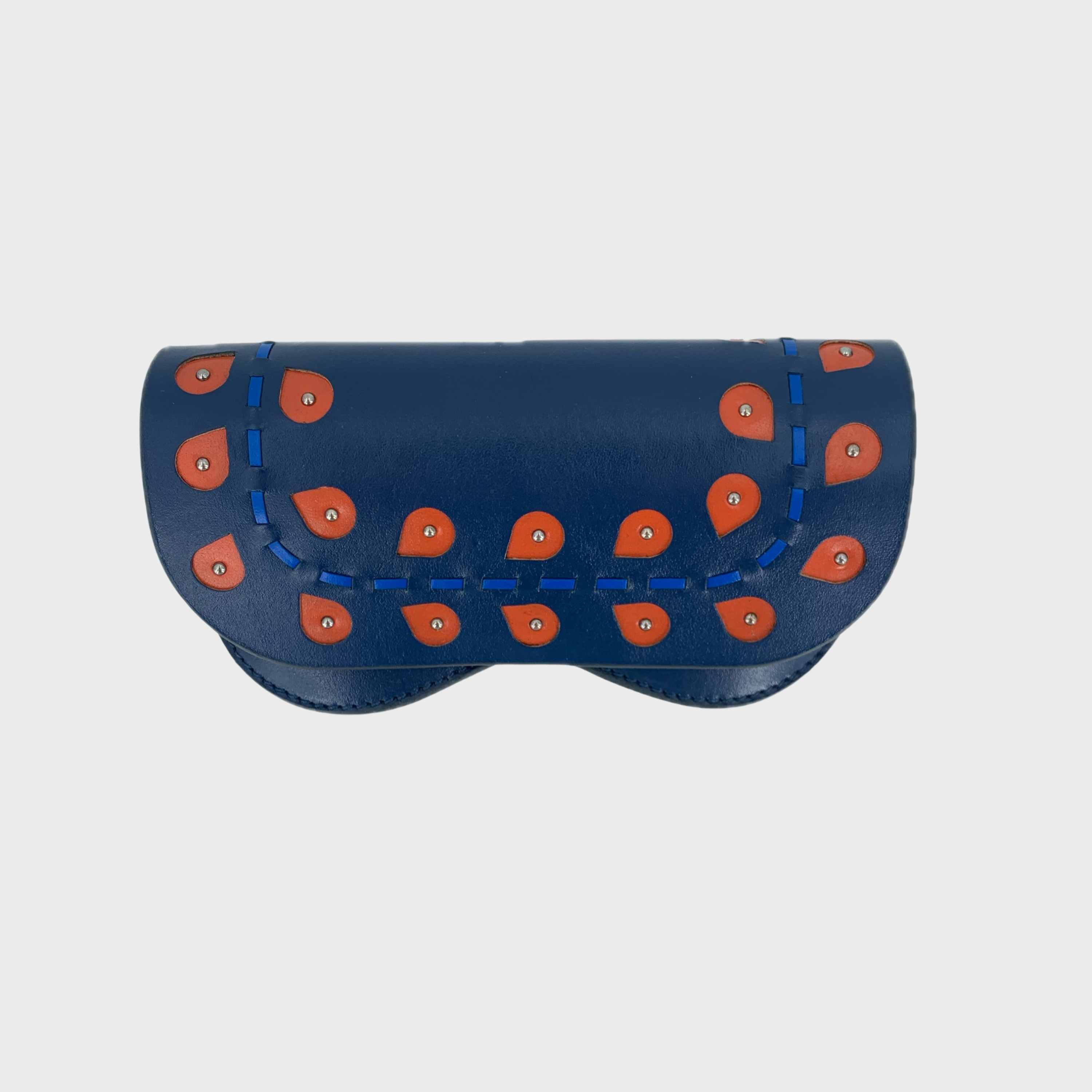 A leather blue glasses case with embroidered red leaves on it. 