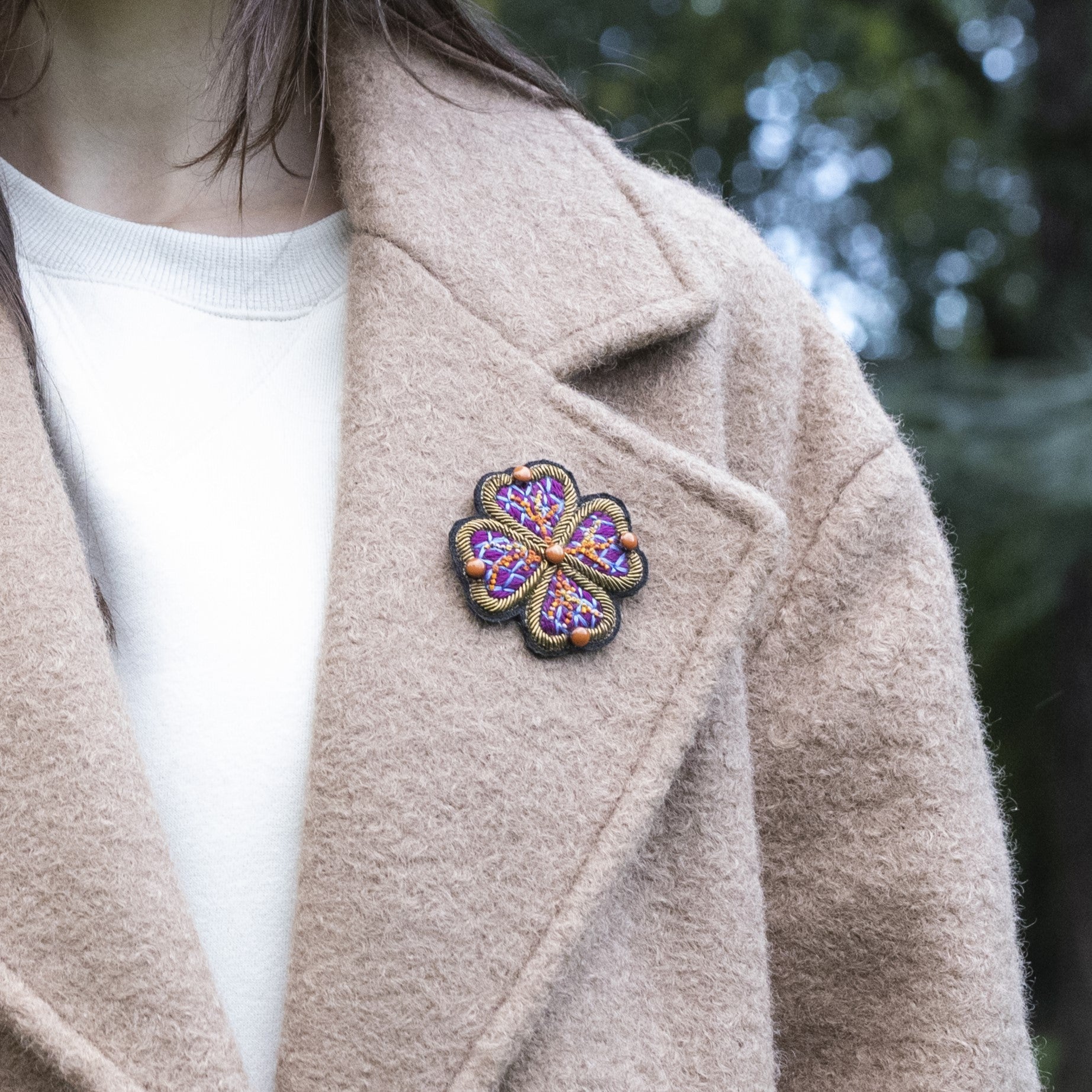 A model wearing the purple love flower on her coat. 
