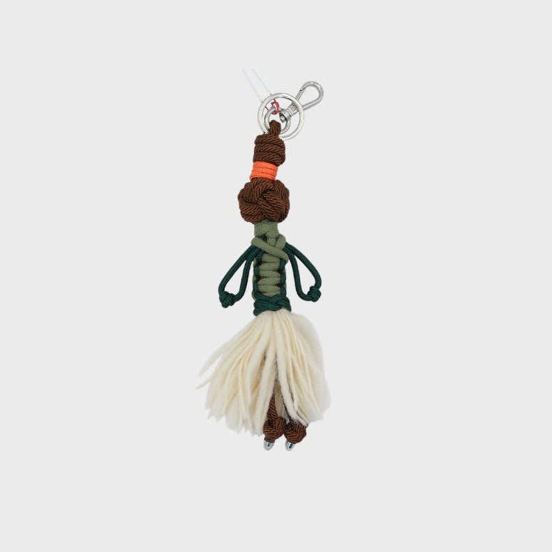 Keychain with a figure made of braided materials on a light gray background