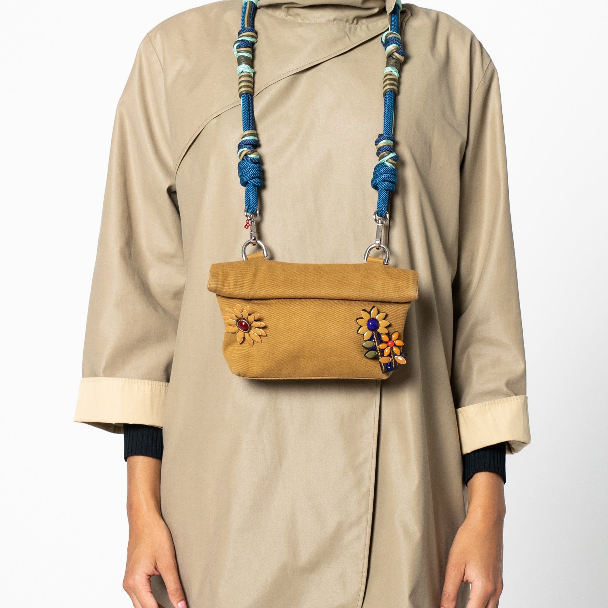 A model wearing a manuka bouquet brooch on a max handbag. 