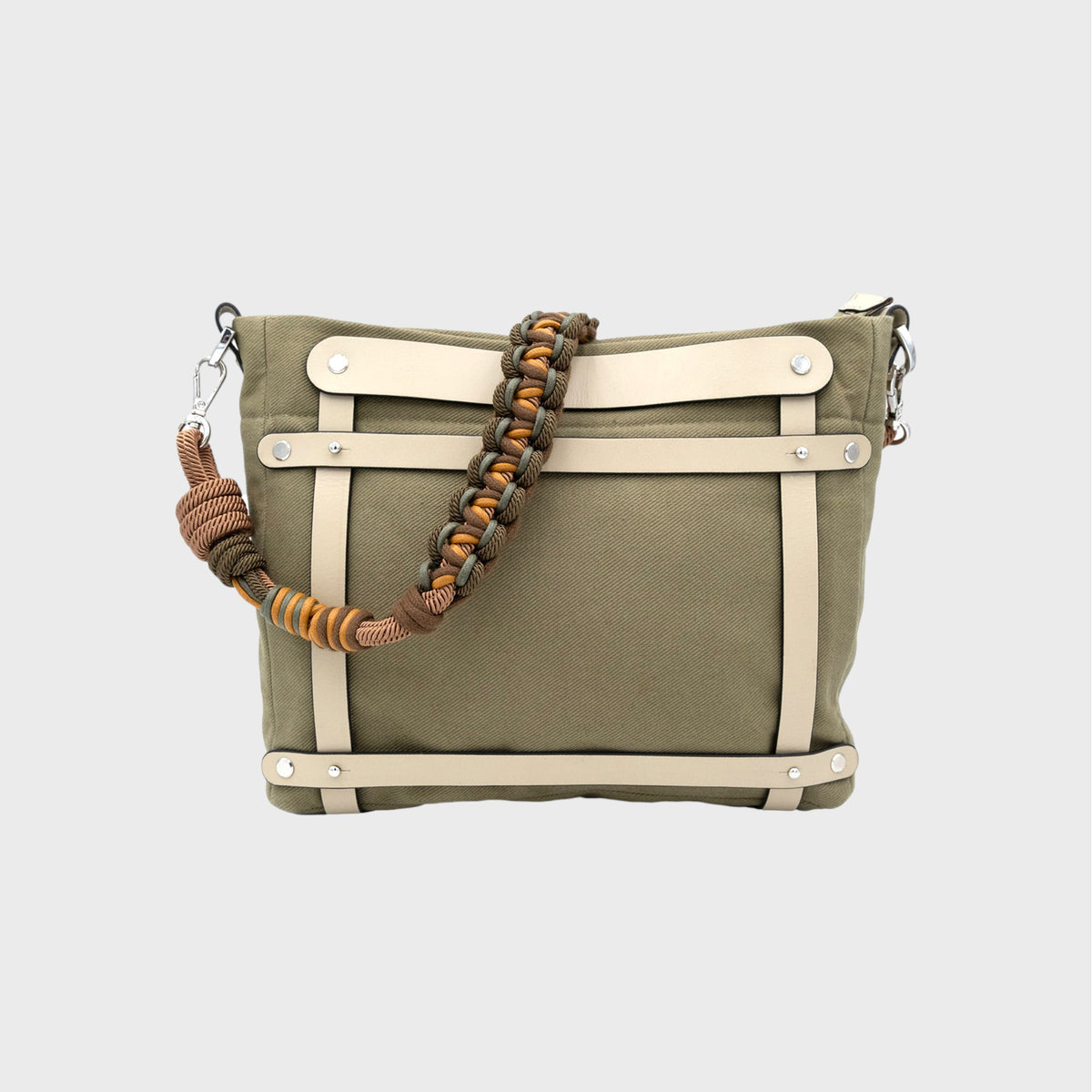 Green handbag with beige strap and braided green, yellow and brown macrame strap on a light gray background.
