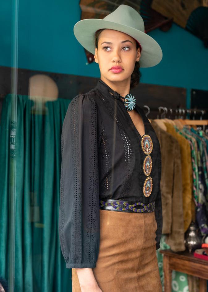 Model wearing the black leather belt with embroidered snake pattern.