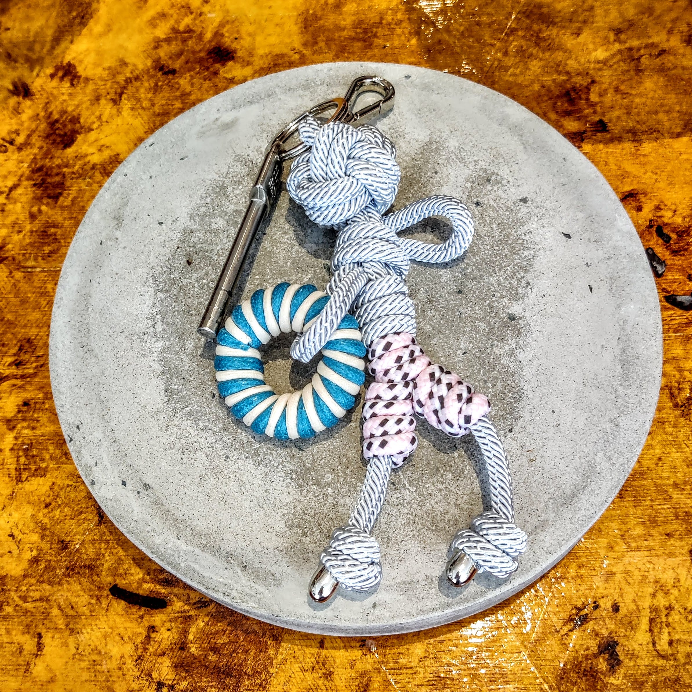 Charlie bag charm shown on brown table top with keys attached.