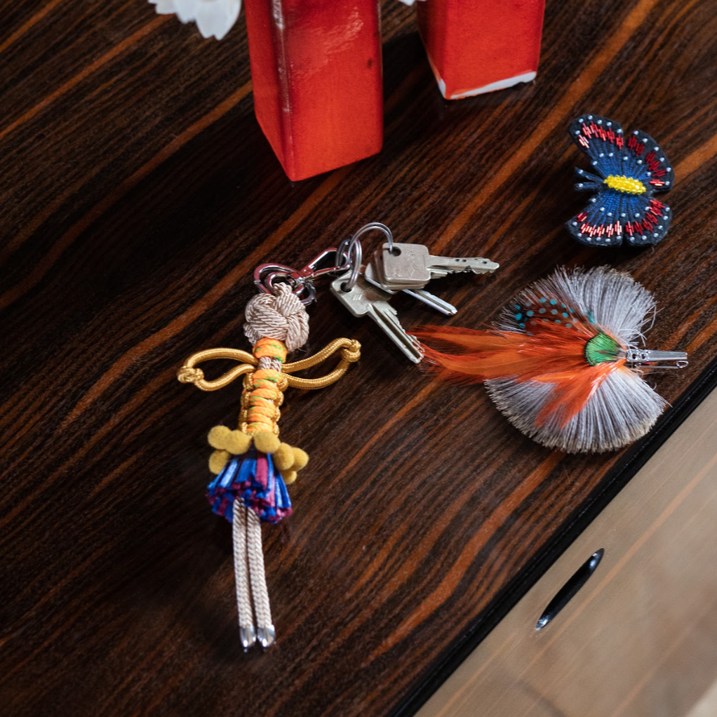 Hema bag charm shown on wooden table top with keys attached.