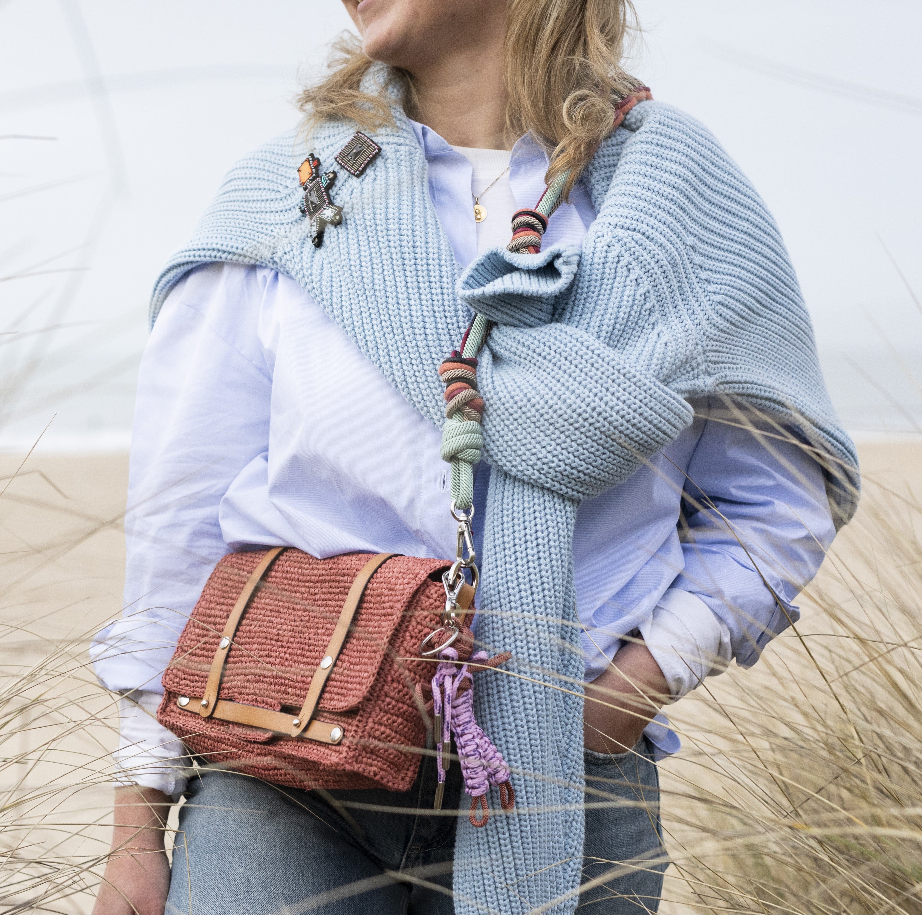 Model wearing the Bihan Shoulder bag paired with a multicolored braided macramé bag strap in soft light blue, soft pink, and burgundy.