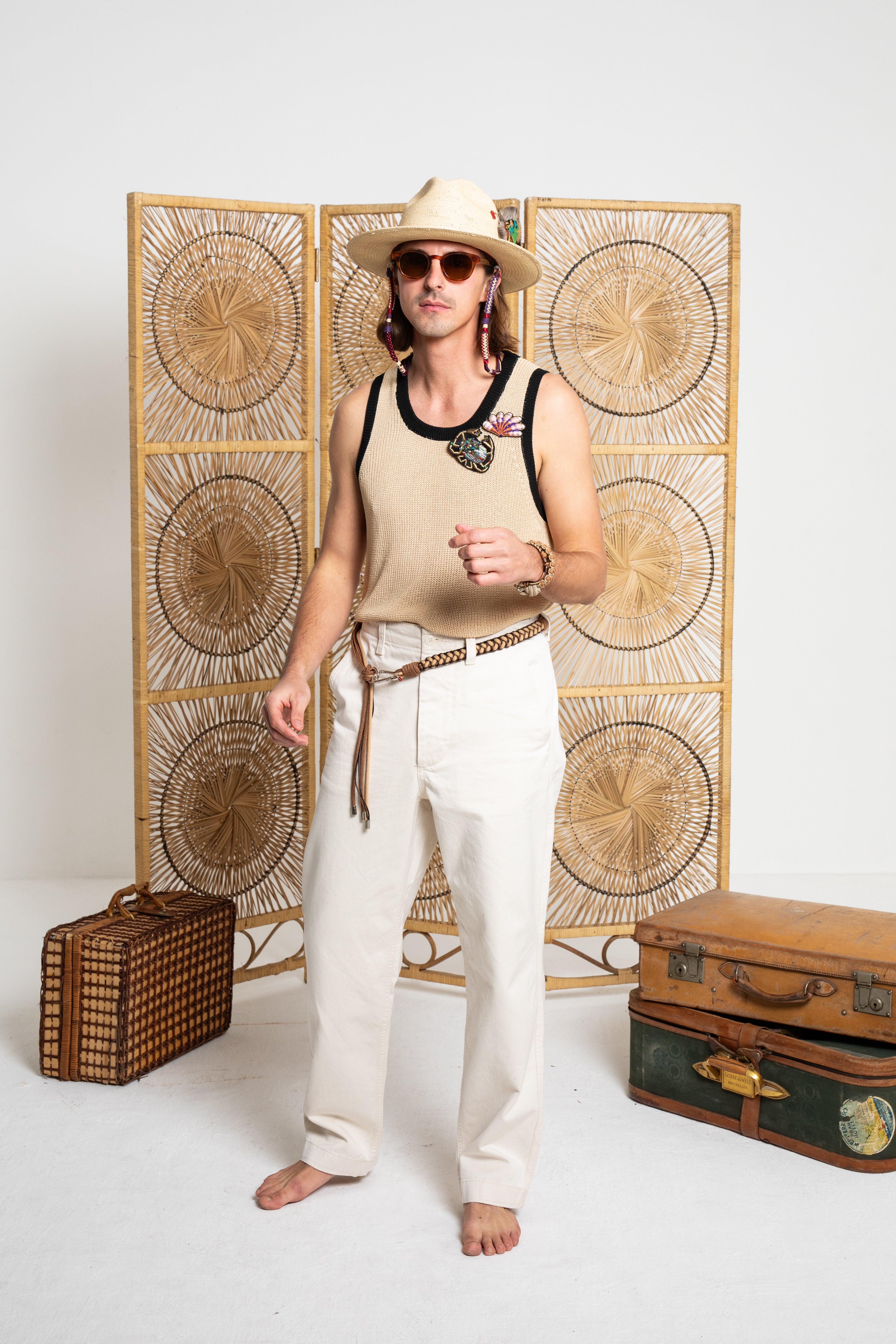 Model wearing the clack, brown and beige belt around white trousers.