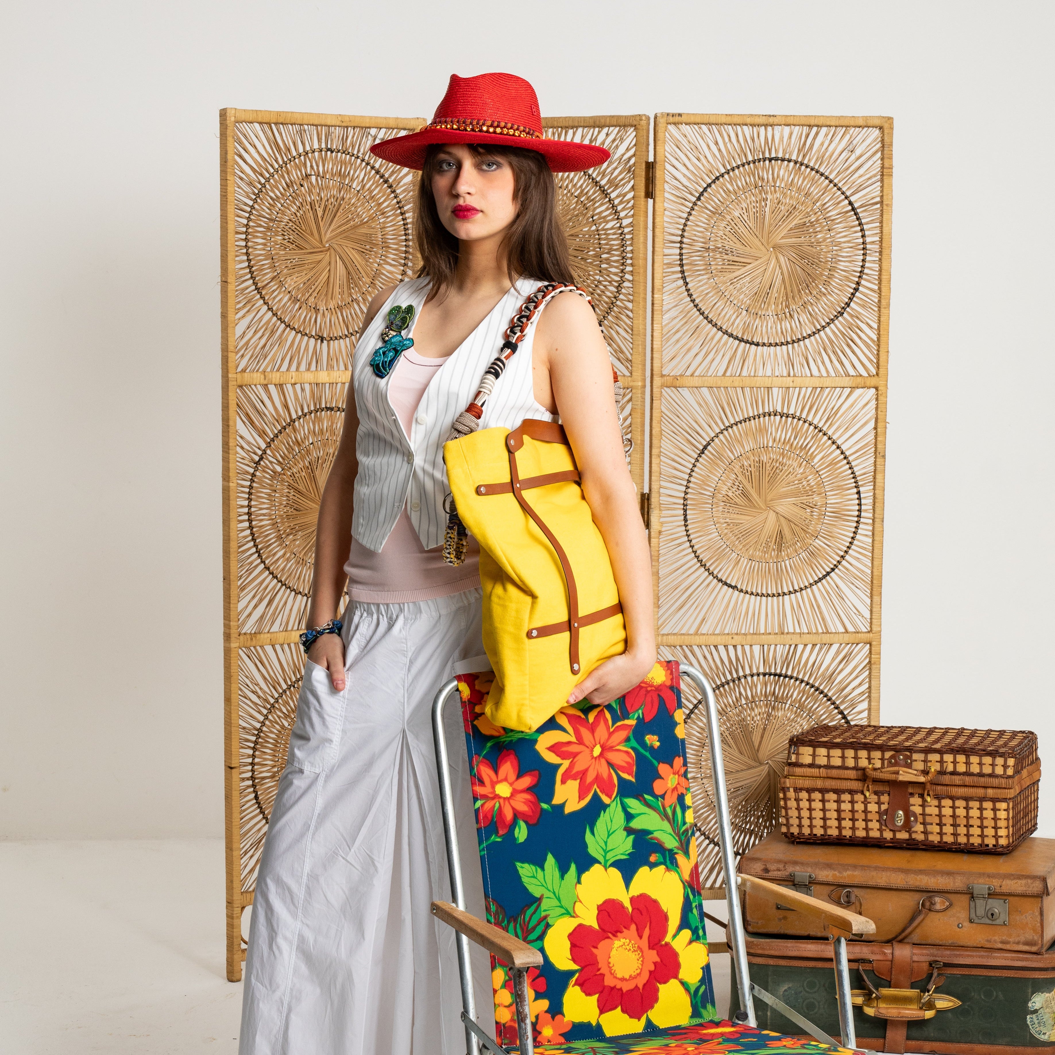 A model carrying on her should the yellow canva optimiste tote bag with the brown leather. 