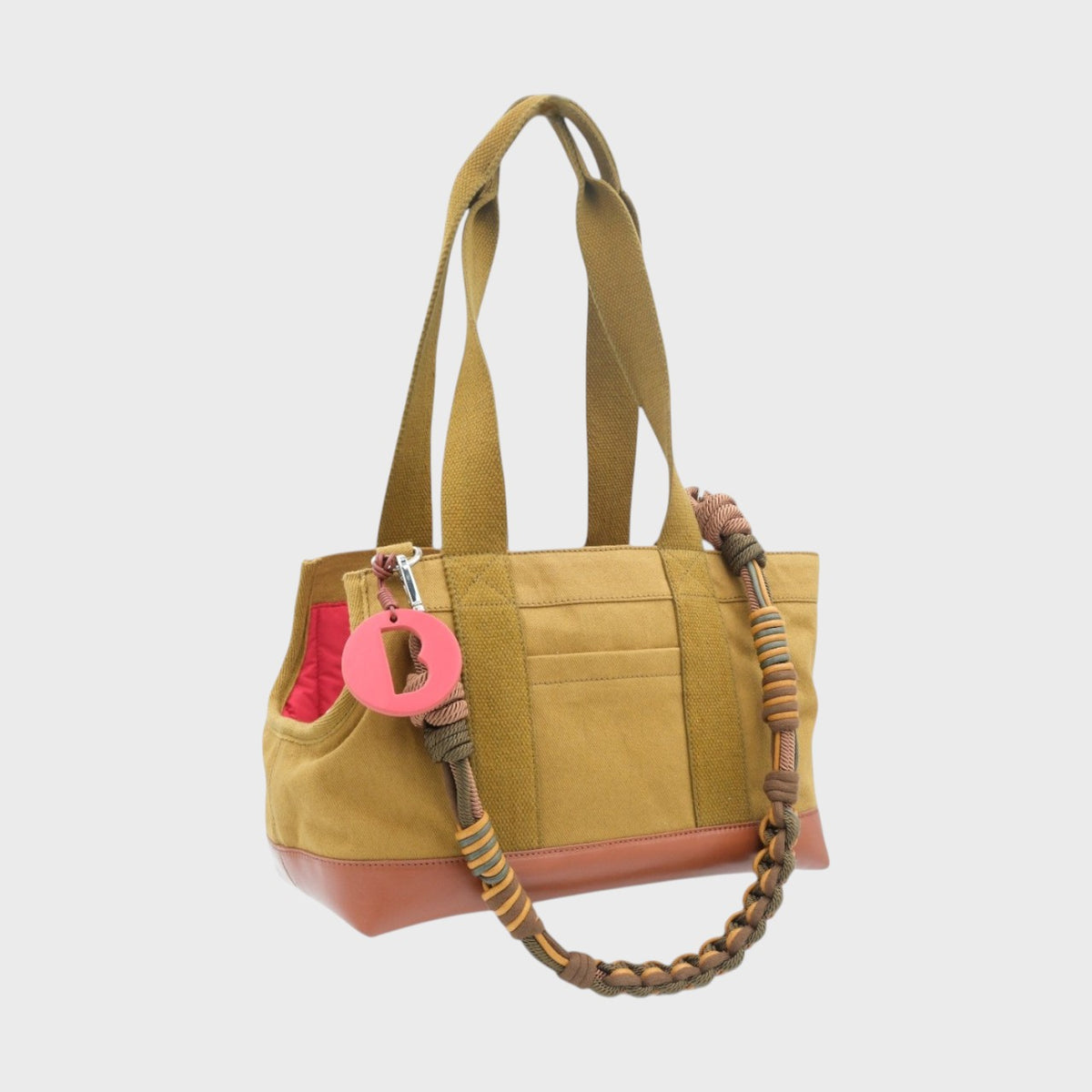 Mustard handbag with a decorative forest brown strap on a white background. 