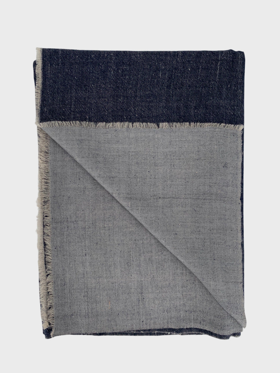Navy and gray cashmere shawl with fringed edges on a light gray background