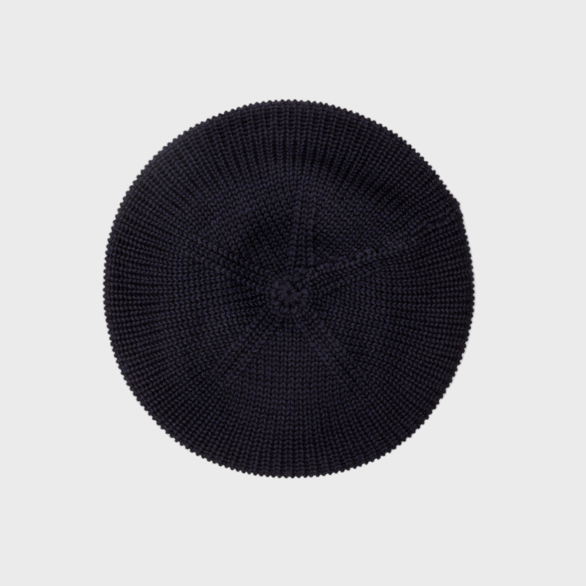 Navy blue knit beret on a light gray background