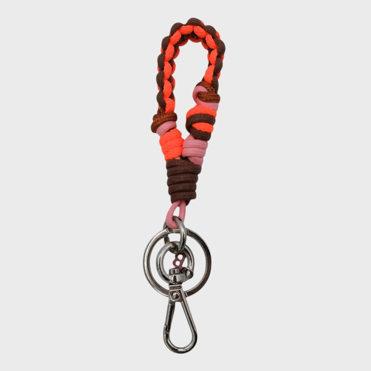 A braided macramé keychain or bag clip in brown, orange and neon orange, featuring a silver metal clasp. 