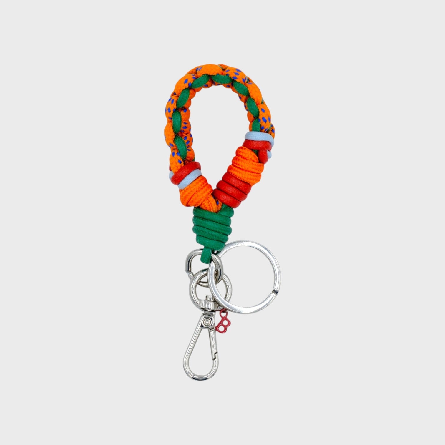A braided macramé keychain or bag clip in orange, red and green, featuring a silver metal clasp. 