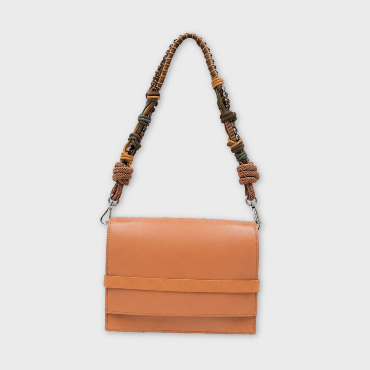 A structured tan leather shoulder bag with a wide horizontal band across the front flap and a knotted woven strap in brown, beige, and muted green tones, shown against a light gray background.