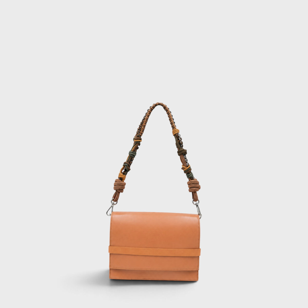 A structured tan leather shoulder bag with a wide horizontal band across the front flap and a knotted woven strap in brown, beige, and muted green tones, shown against a light gray background.